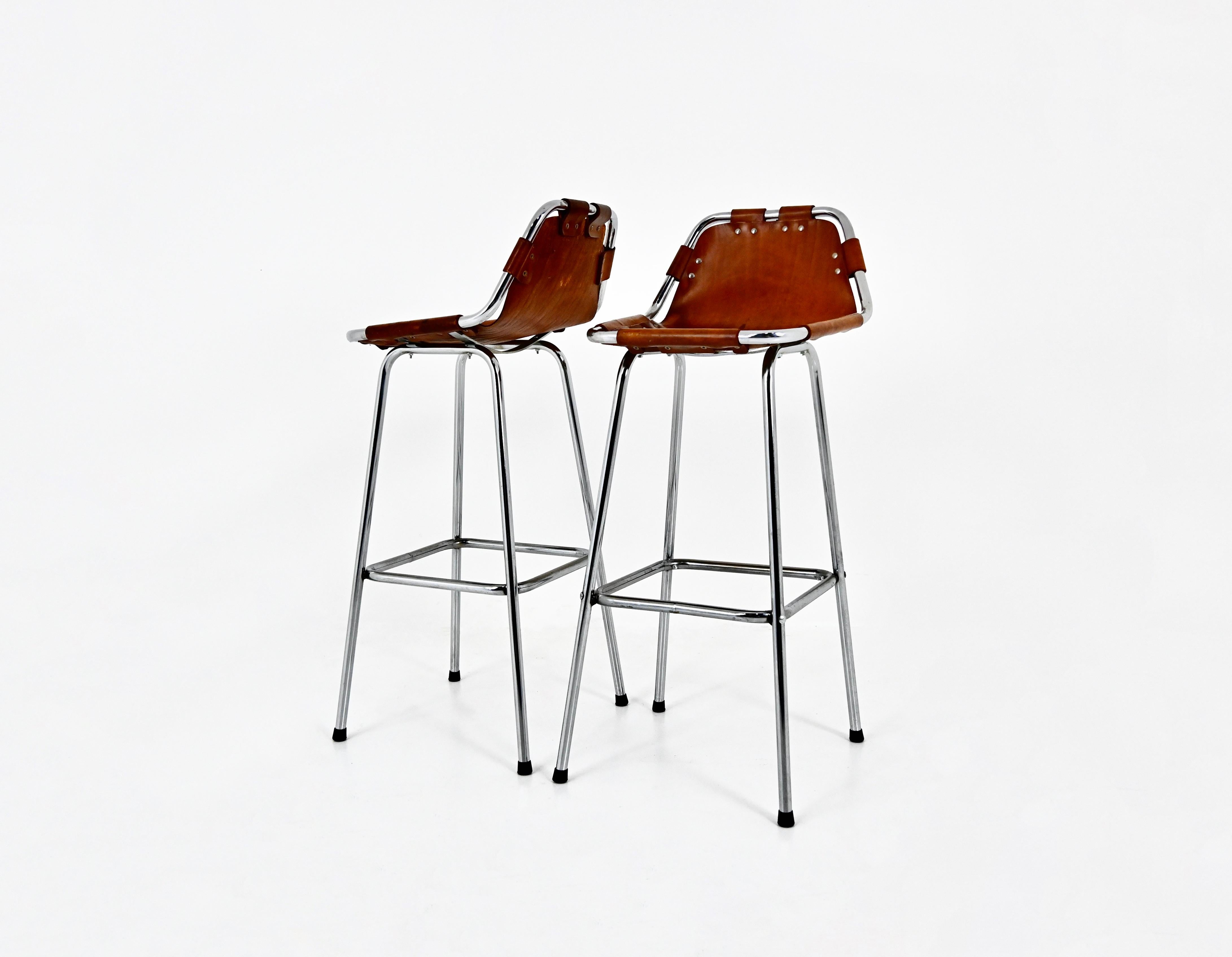 Set of 2 stools in leather and chromed metal. This model was designed by Charlotte Perriand for the French ski resort of Les Arcs in the 1960s. Seat height: 43 cm. Wear due to time and age of the stools.
FOR SHIPPING, REQUEST US FOR RECEIVE THE BEST