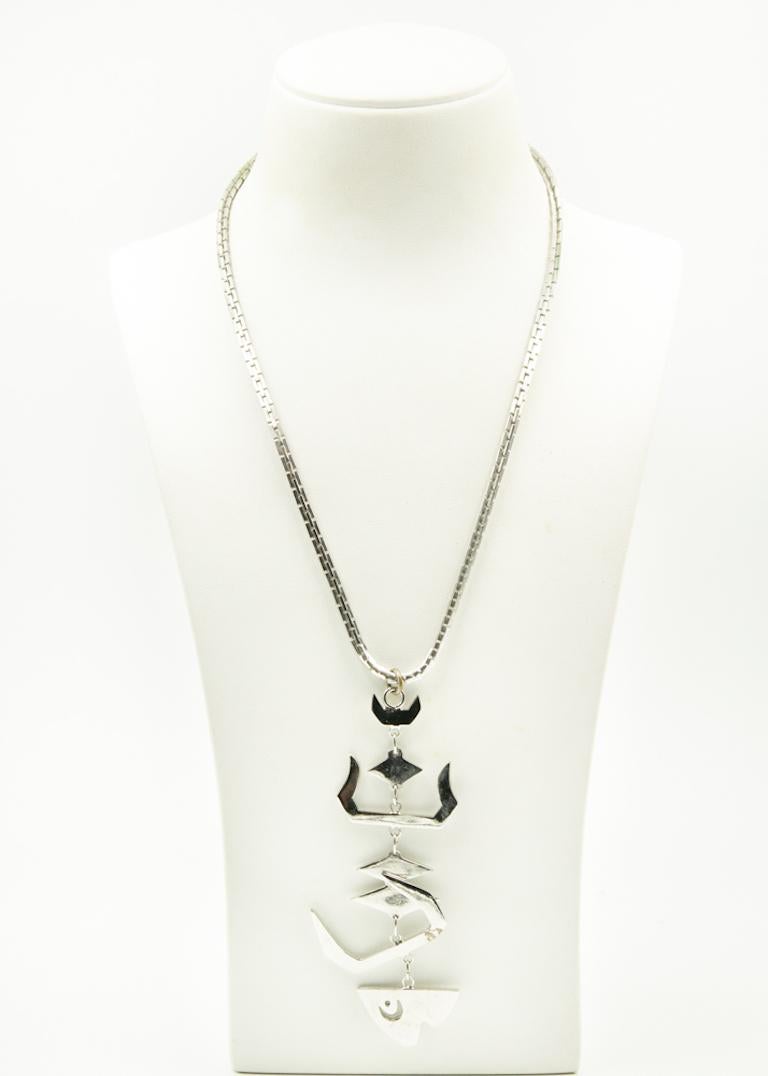 Fun 1960s Les Bernard dangling fish pendant necklace featuring an abstract chrome plated fish on box link silver tone chain.  The chain has a Les Bernard Inc. hang tag.  The section of the fish above the head has an area where the plating is peeling