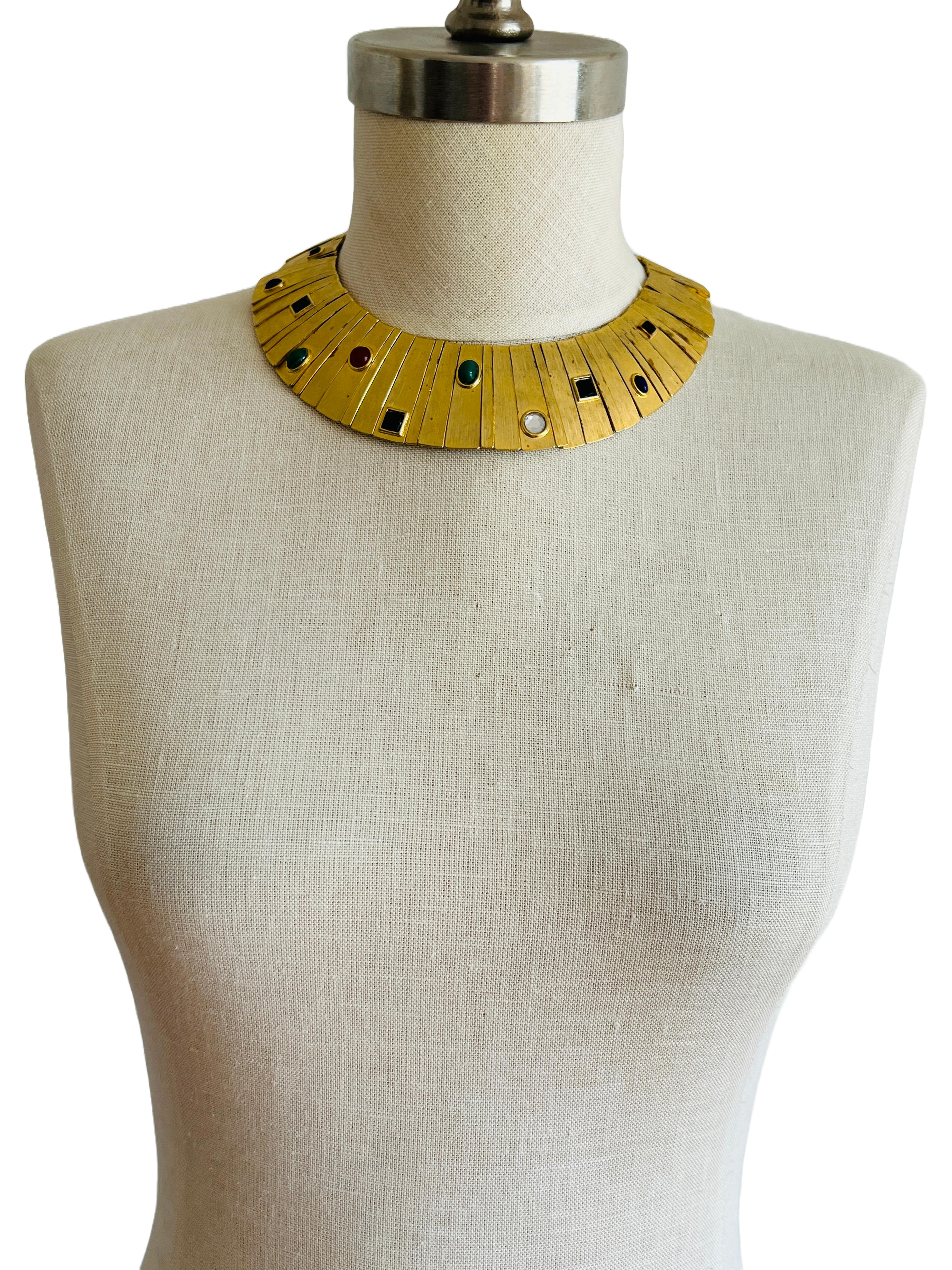 This exquisite vintage Les Bernard cabochon collar necklace is a striking example of the brand's iconic designs from the 1960s-1980s. Crafted with a bold and elegant pale gold-tone finish, the necklace features a series of multi-colored cabochon