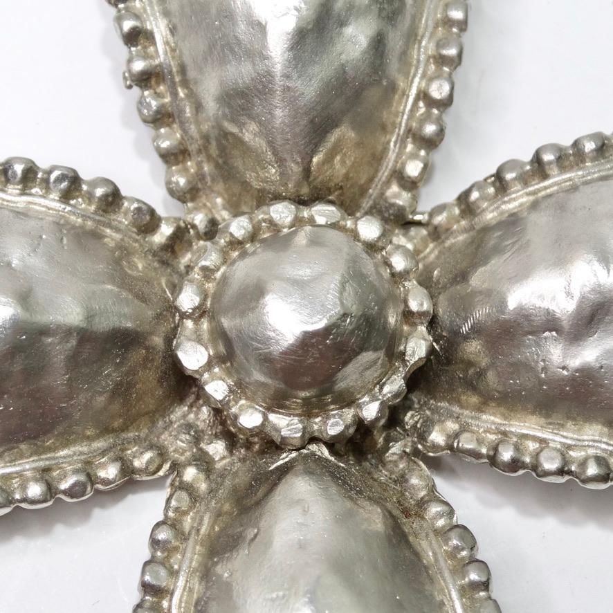 This vintage Les Bernard cross brooch is the perfect way to add a shiny pop to any outfit! A beautiful textured sterling silver is sculpted in somewhat of a dome style to create this eye catching cross motif. Surrounded by intricate circle