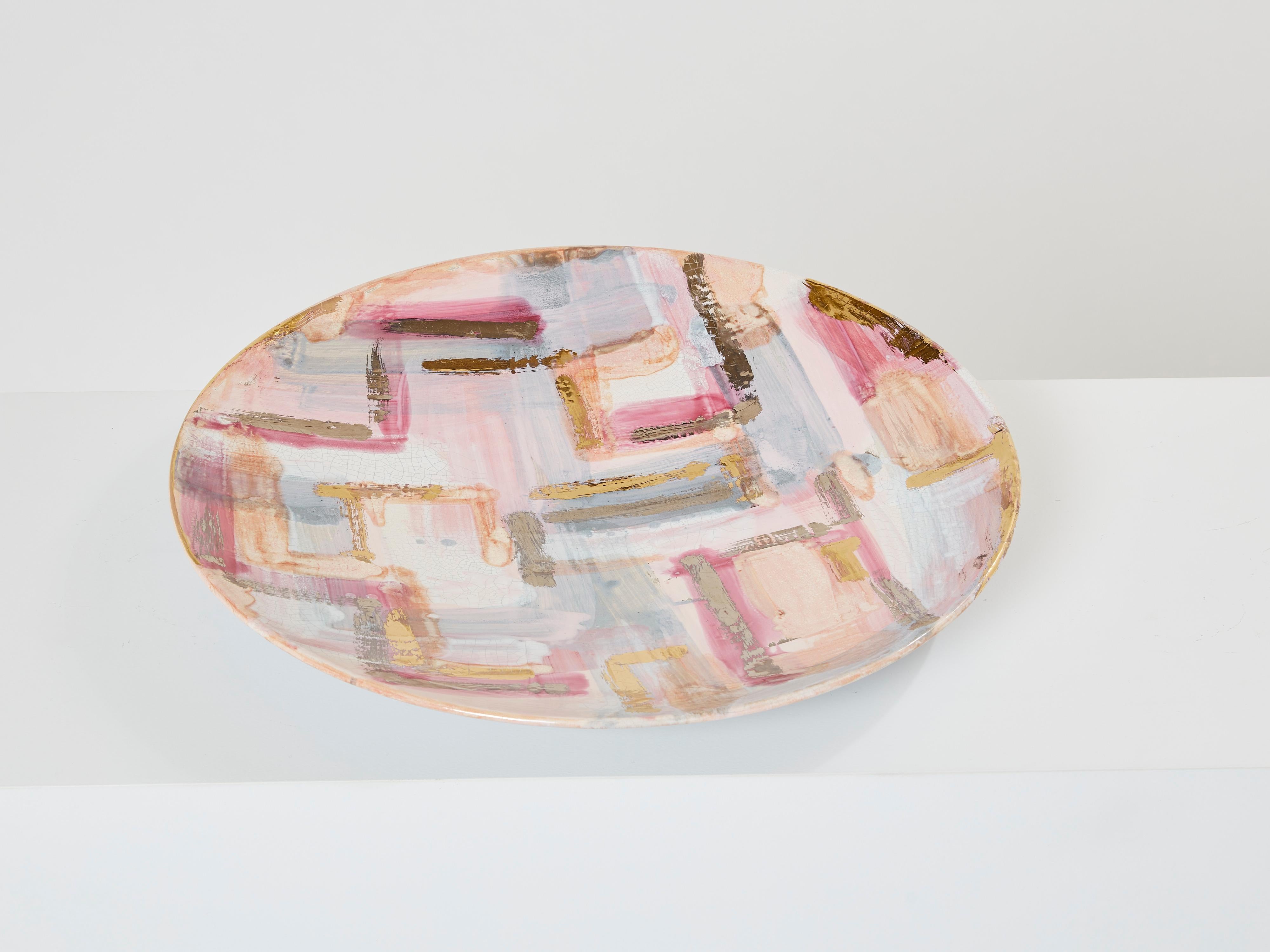 Dieser farbenfrohe, emaillierte runde Keramikteller wurde Anfang der 1990er Jahre von Les Héritiers in Frankreich entworfen und hergestellt. Dieser große Teller hat auffällige Pastellfarben, mit vergoldeten Details und Craquelé-Glasur rundherum.  Er