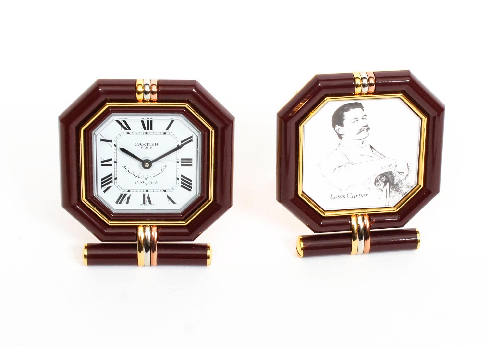This is a stunning and exquisitely made Les Must de Cartier maroon and gilt desk clock and photograph frame twin set complete with the original red Cartier satin lined case.
 
Both the clock and the photo frame have matching octagonal shapes and