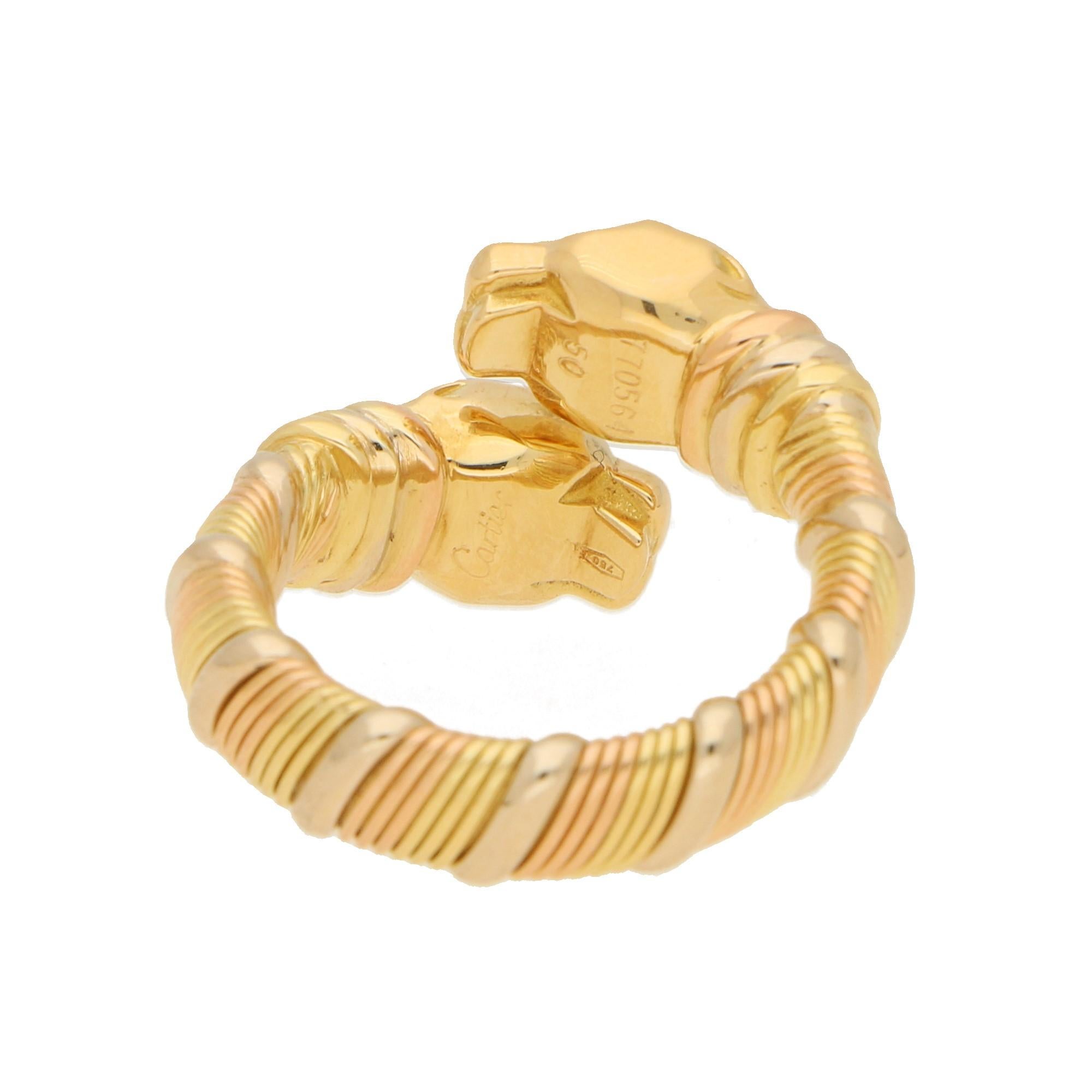 A beautiful Panthère de Cartier double headed crossover ring set in 18 karat rose, yellow and white gold. 

This ring is of an openwork design formed of two polished yellow gold panther heads, connected by a tri-colour gold coiled shank. It wold