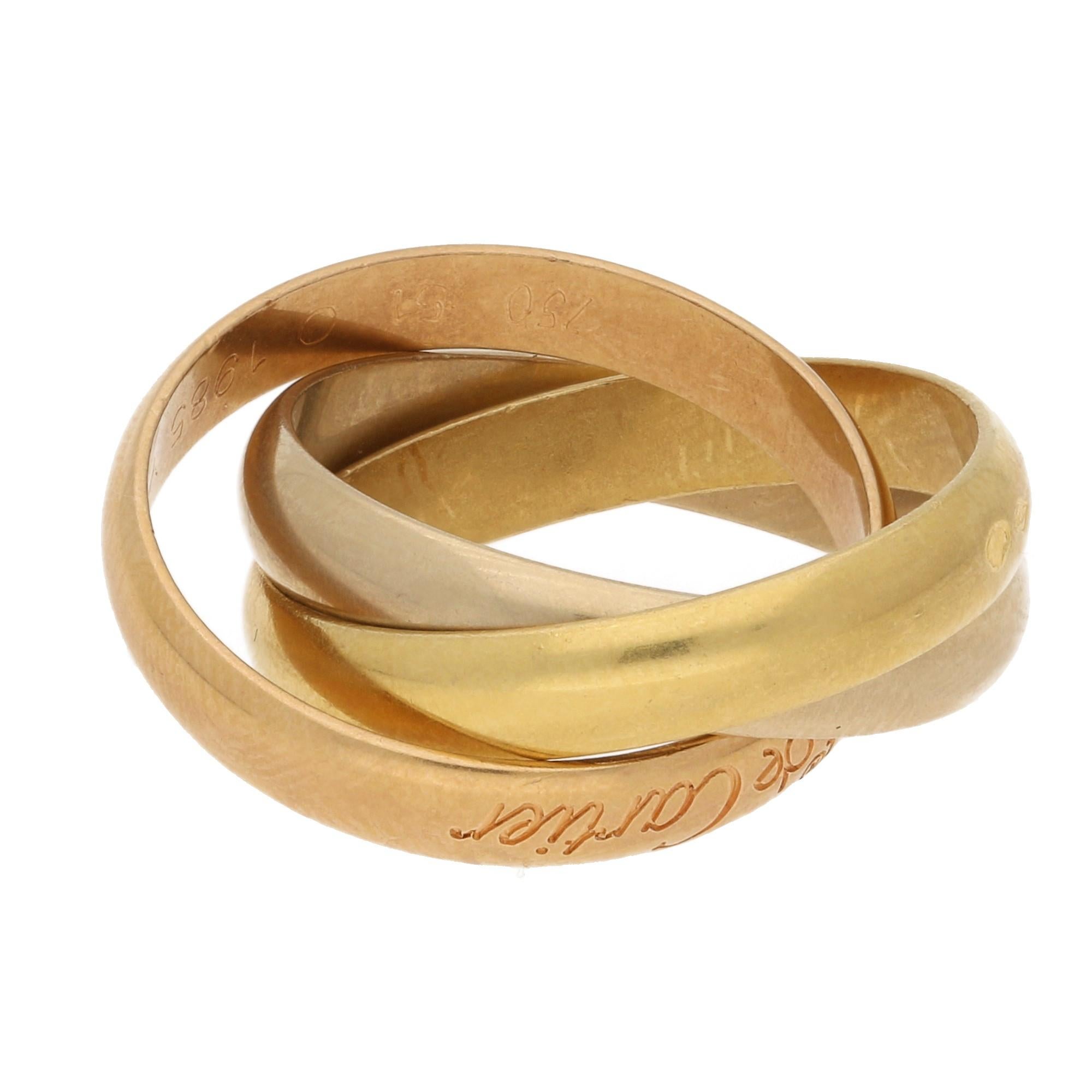 A classic trinity tri-colour ring in 18 karat yellow, white and rose gold by Cartier, signed on the rose gold band 'Les Must De Cartier' with French maker's marks on each of the insecting bands. UK size K, US size 5.5.