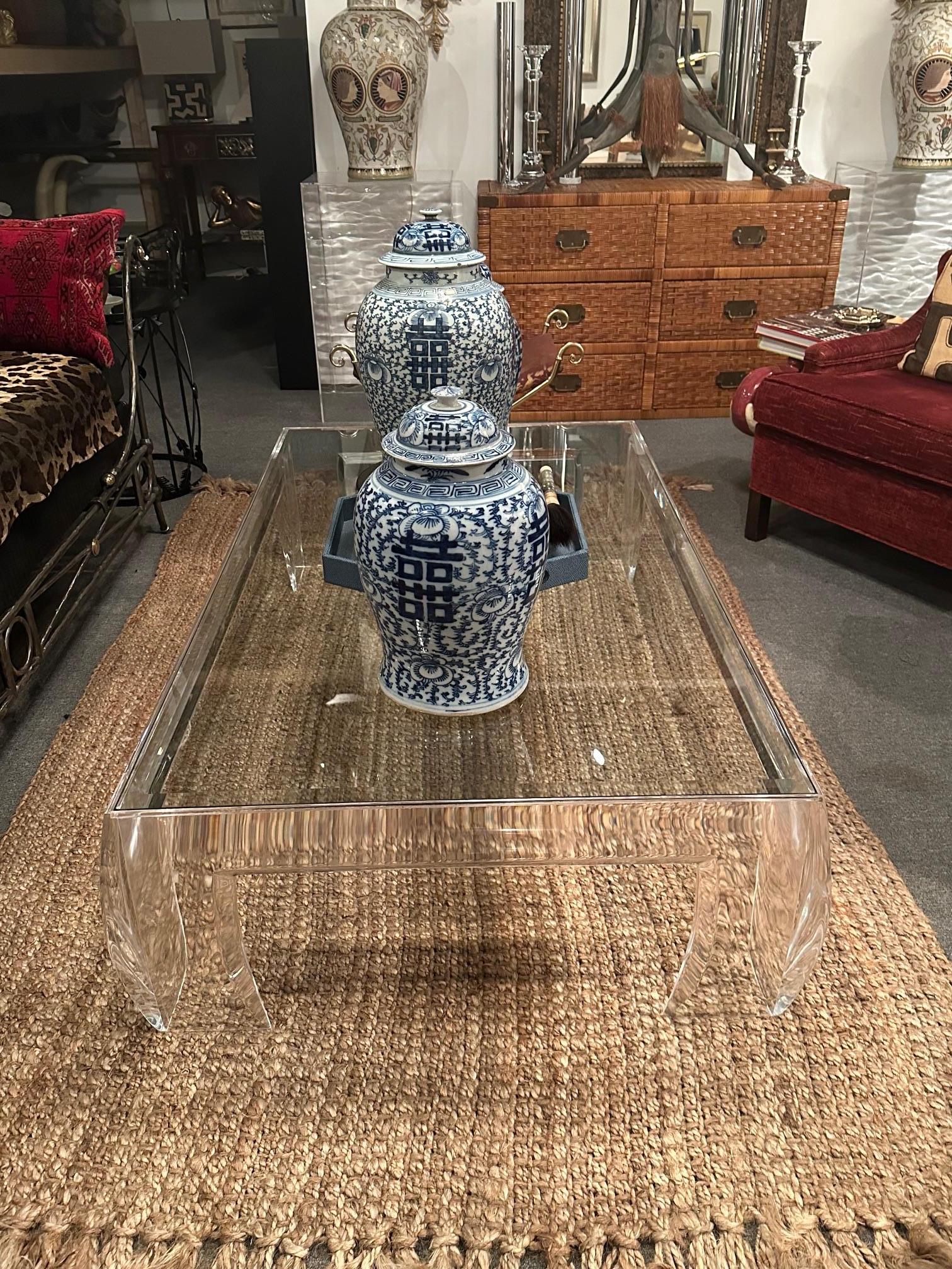 Beeindruckender, großer, dramatischer Lucite-Couchtisch mit Glasplatte und ausladenden Beinen, die einen Hauch von asiatischem Einfluss haben. 
Unterschrift auf dem Bein