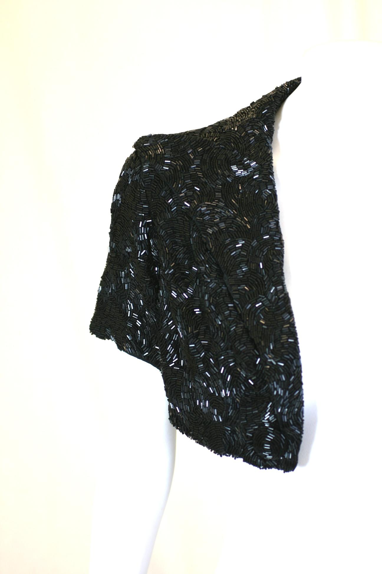 Art Deco Haute Couture Lesage bead embroidered short bolero short sleeved jacket. Of black jet vari size vermicelli tube beads patterned in overlapping scalloped swirls on silk crepe. The open jacket is tuxedo styled with large beaded lapels and two