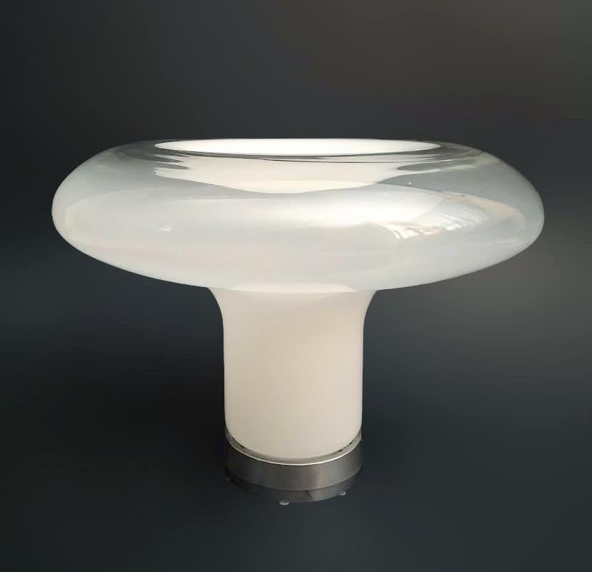 Lámpara de sobremesa Lesbo original italiana de primera edición con pantalla de cristal de Murano opaco esmerilado blanco y transparente soplado a mano en forma de seta escultural, montada sobre base de aluminio / Made in Italy in 1967
Diseñado por