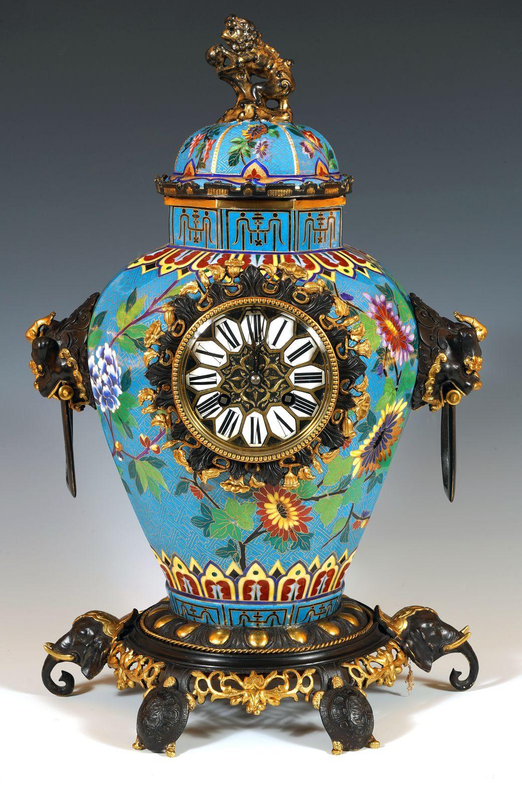 Rare Chinese style clock in the shape of a covered pot, in porcelain painted in imitation of Chinese cloisonné enamel and decorated with a two-patina bronze mount. The dome-shaped cover is topped with a Fô dog. A rotating decoration of
