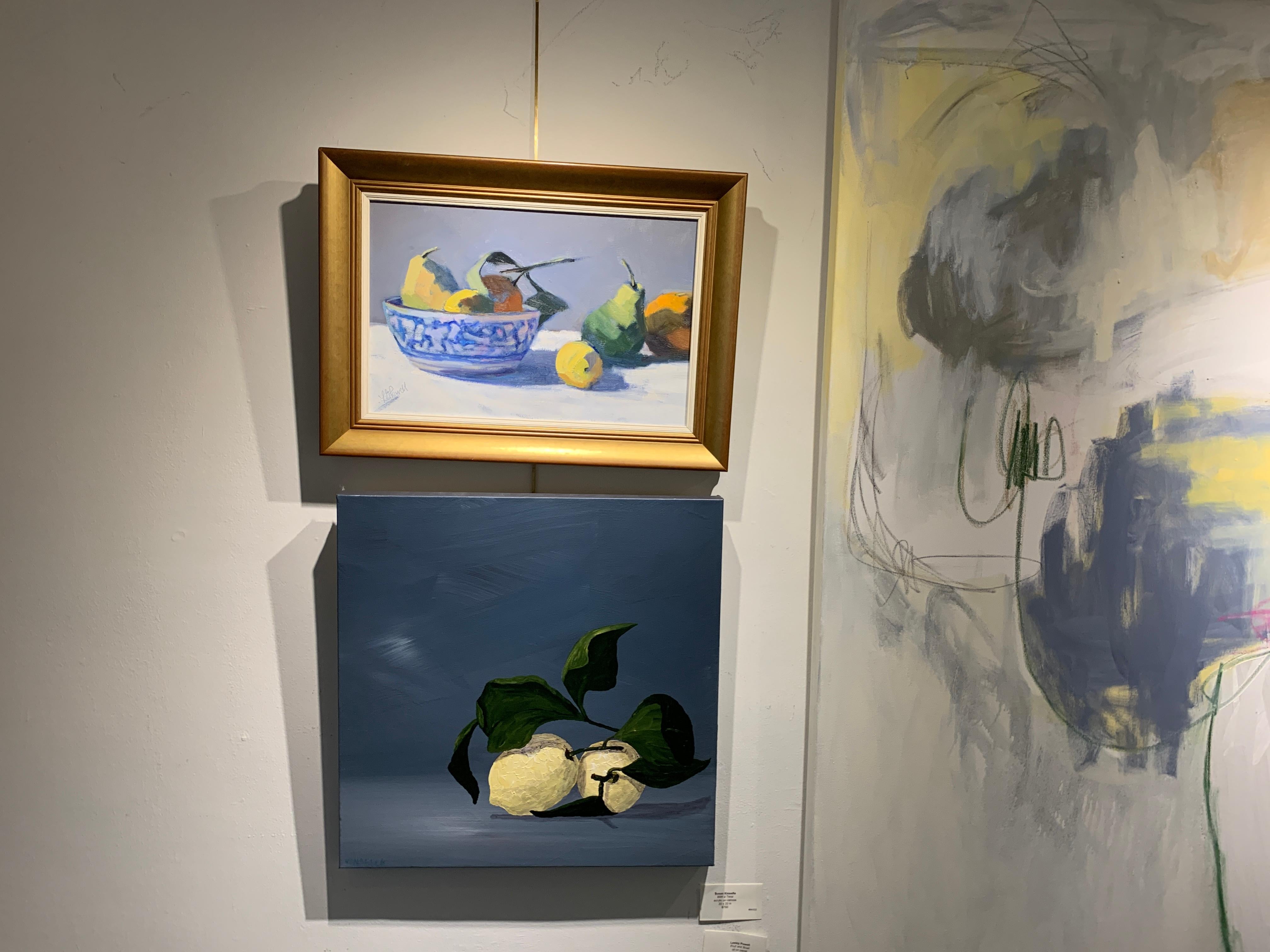 'Fruit and Bowl' is a small framed Post-Impressionist still-life painting of horizontal format, created by American artist Lesley Powell in 2019. Featuring a palette made of yellow, blue, green, orange and white tones, the painting depicts a