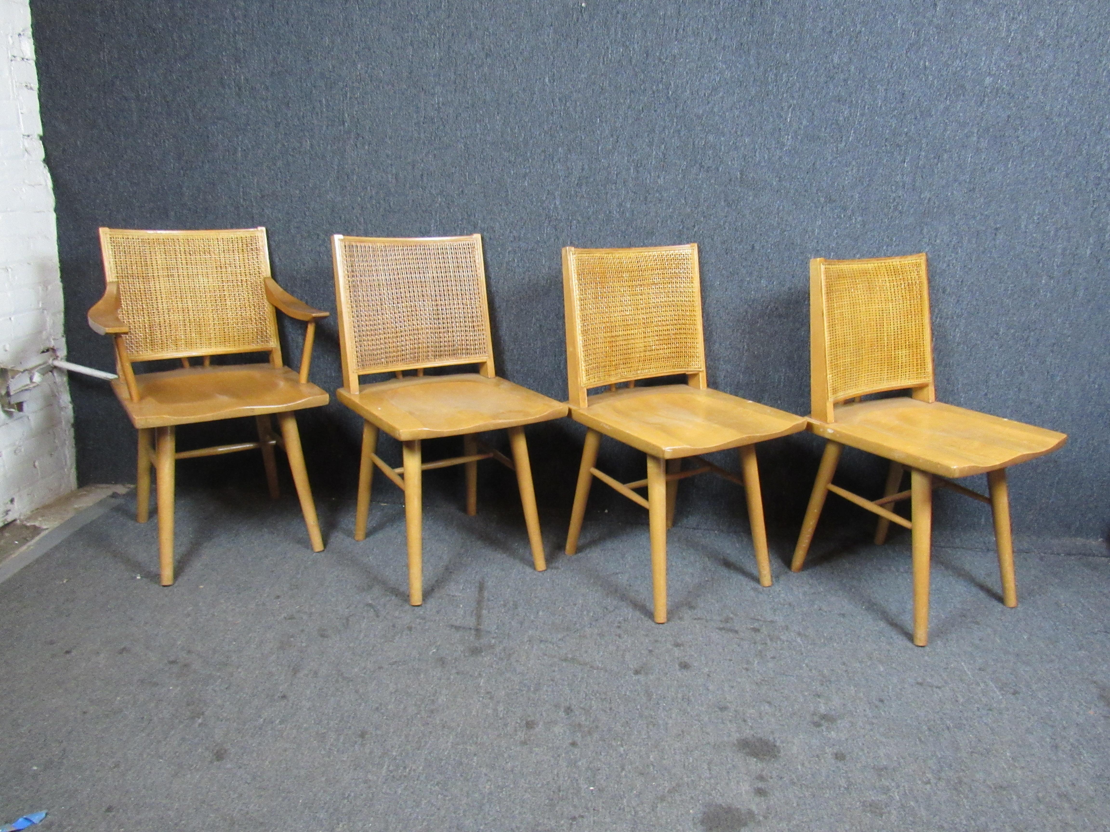 Absolutely charming set of four vintage maple and wicker dining chairs designed by Leslie Diamond for Conant Ball. The light-hued wood grain is sure to shine in any number of settings. A lovely wicker back adds to their timeless appeal. Set includes