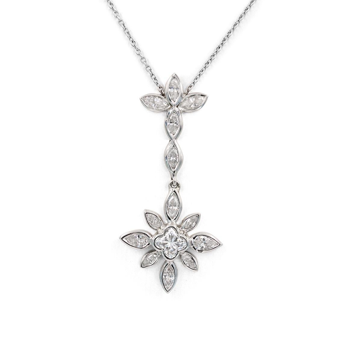 This Lester Lampert original flower pendant in 18kt. white gold contains a center lilly cut diamond = .43ct, 11 marquise diamonds = .83ct. t.w., and 2 pear shaped diamonds = .22ct. t.w. All diamonds are G in color and VS in clarity. 

The necklace