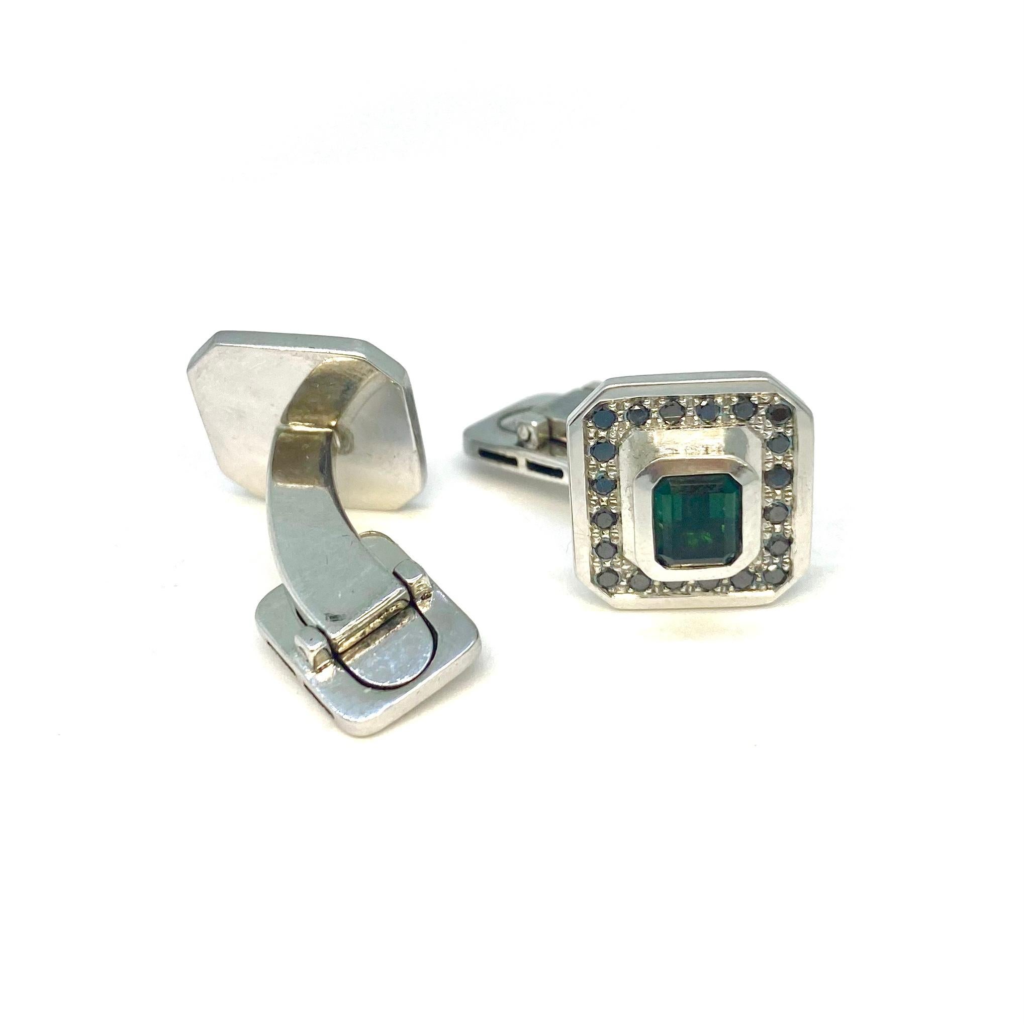 Cufflinks in polished white gold 750/ 18K with green, emerald cut tourmalines 2,3ct and 40 black brilliant cut diamonds 0,60ct.

Designed for the complete gentleman, our white gold black diamond cufflinks are the epitome of refined elegance. These