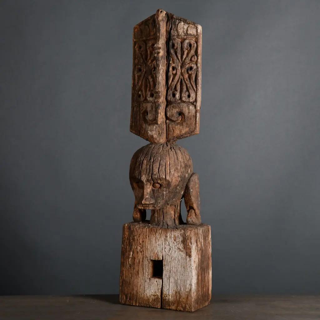 Questa statua dell'antenato Leti, scolpita a mano in legno patinato, proviene dalla piccola isola indonesiana di Leti. Raffigurante una figura ancestrale coronata da un elaborato copricapo, un tempo adornava le case tradizionali, fungendo sia da