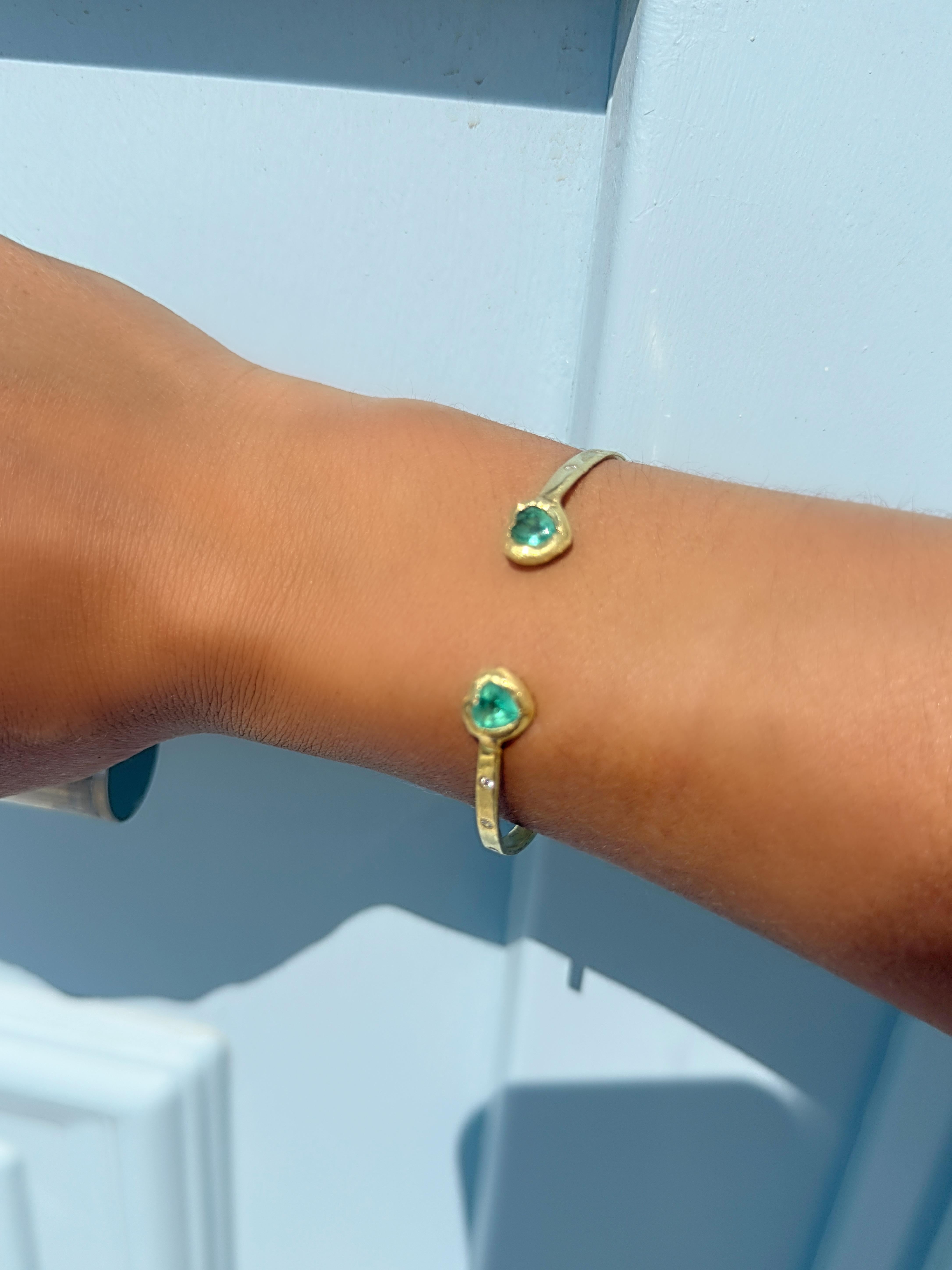  Reinterpretación romántica del clásico diseño toi-moi, este brazalete abierto celebra el encuentro de dos corazones. Hecha a mano en oro de 18 quilates, tiene dos esmeraldas en forma de corazón de un verde intenso, acentuadas con brillantes