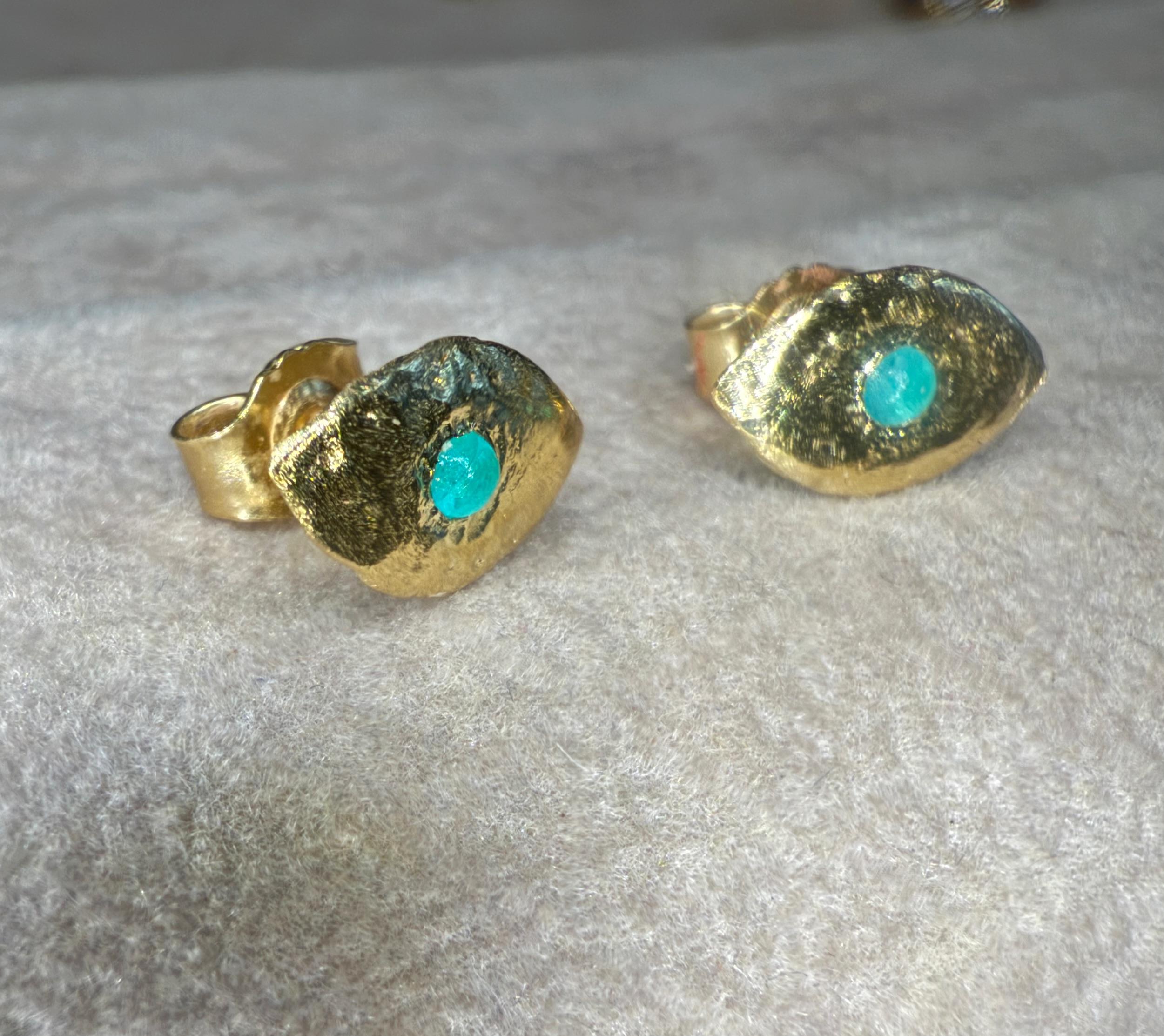 Queste borchie minimaliste, che emanano una luce blu oceano, sono caratterizzate da tormaline naturali brasiliane Paraíba Cabochon incastonate a filo in oro giallo 18 carati. La superficie liscia dell'oro permette alle gemme di brillare come se