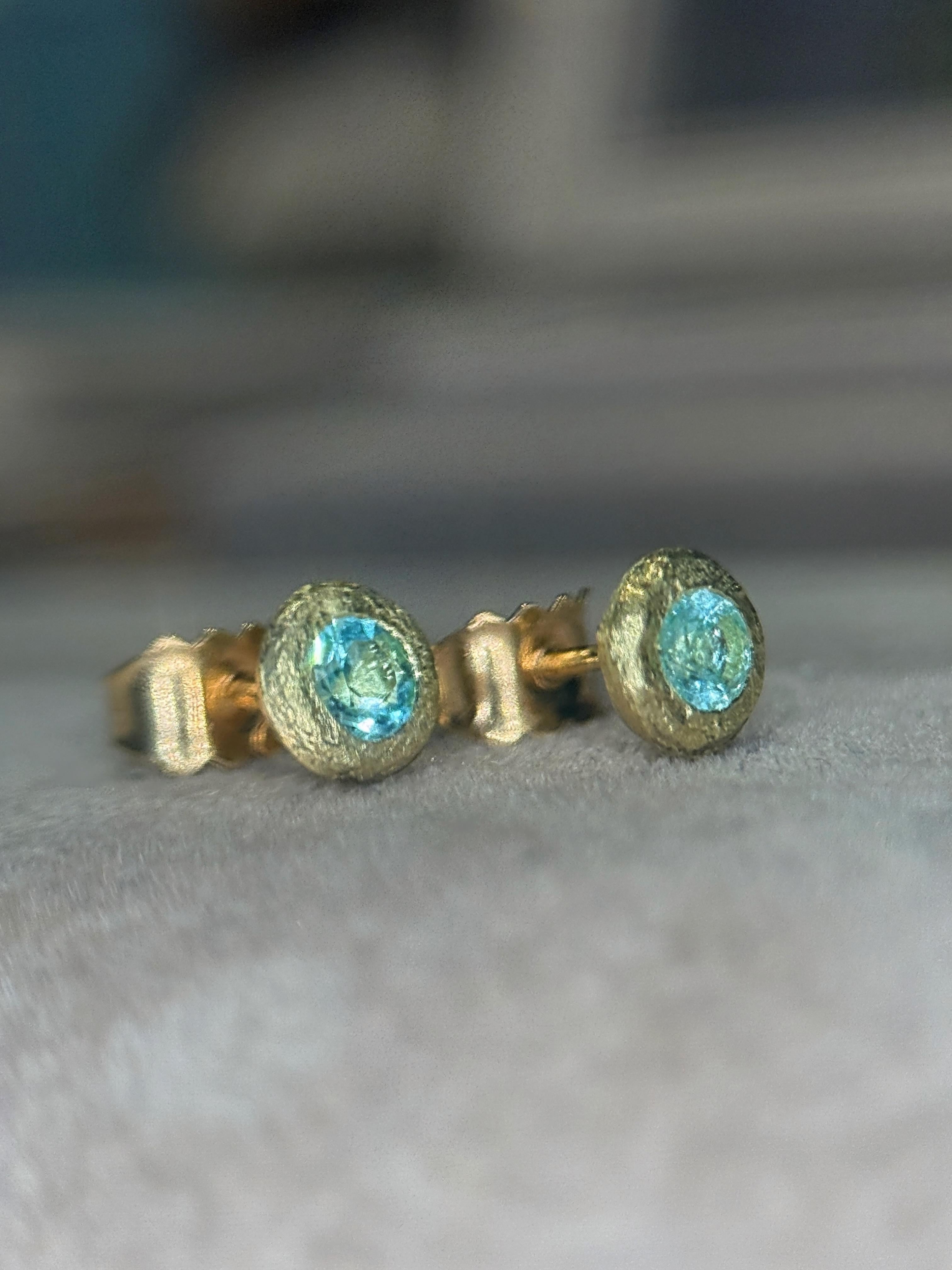 Eleganza elettrica allo stato puro. Queste borchie in oro giallo 18ct incorniciano le rare tormaline brasiliane Paraíba, gemme celebri per il loro splendore blu oceano. Un classico moderno: senza sforzo per tutti i giorni, indimenticabile per tutta