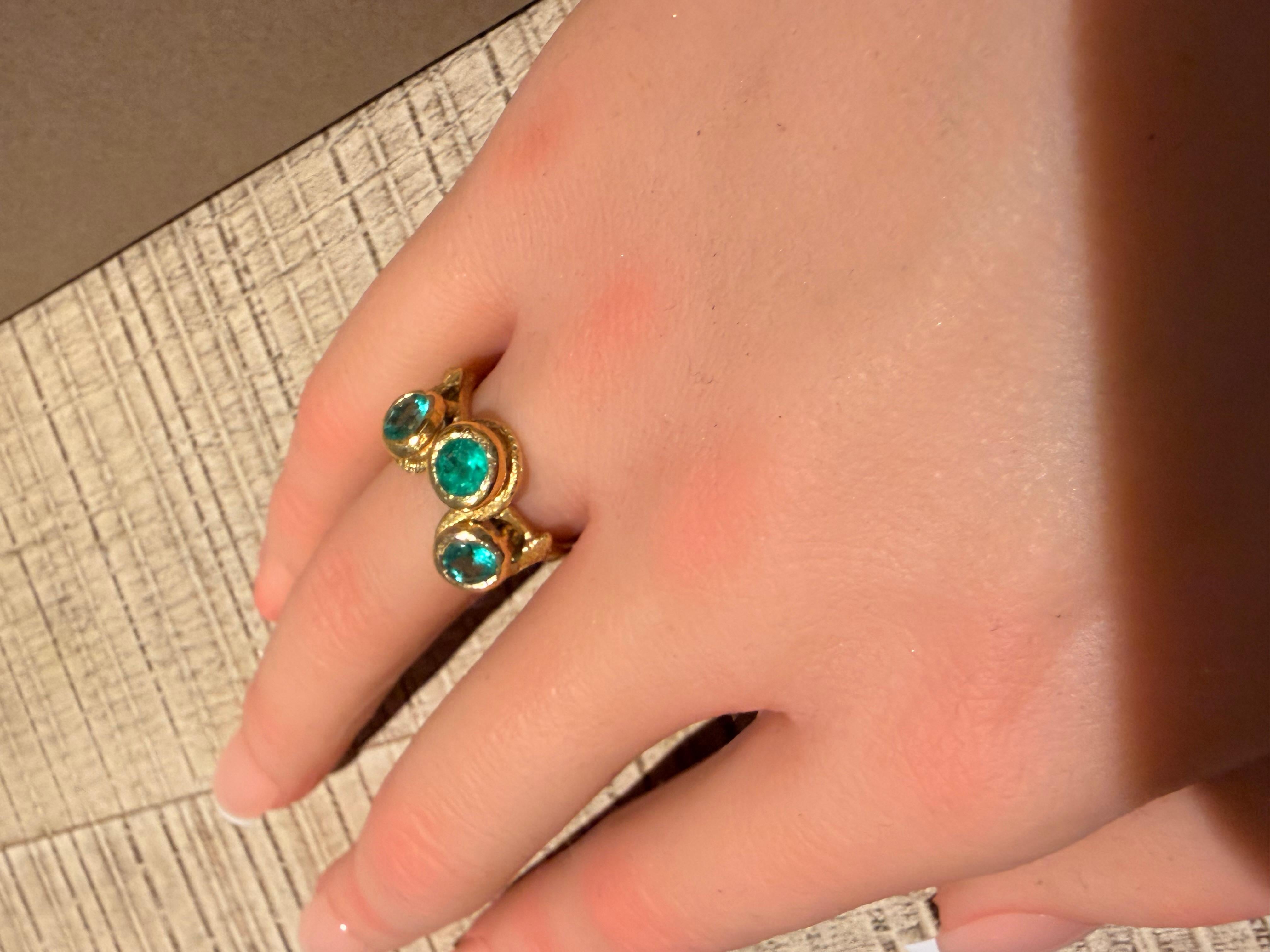 Bague serpent à trois émeraudes

Une bande serpent en or jaune 18 carats s'enroule autour du doigt comme une lumière en fusion, sa forme culminant dans trois émeraudes vivaces qui font miroiter des teintes vertes avec une intensité hypnotique.