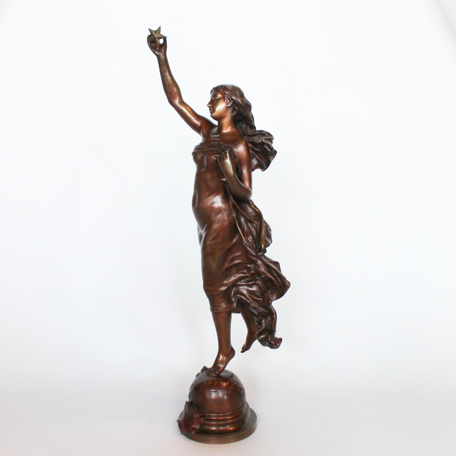 L'Etoile du Matin, an Art Nouveau patinated bronze sculpture of a mythological lady in flowing robes holding aloft a star, perched on a globe decorated with symbols of the zodiac and a sprig of roses.

Signed Gaudez to cast, with applied shield to