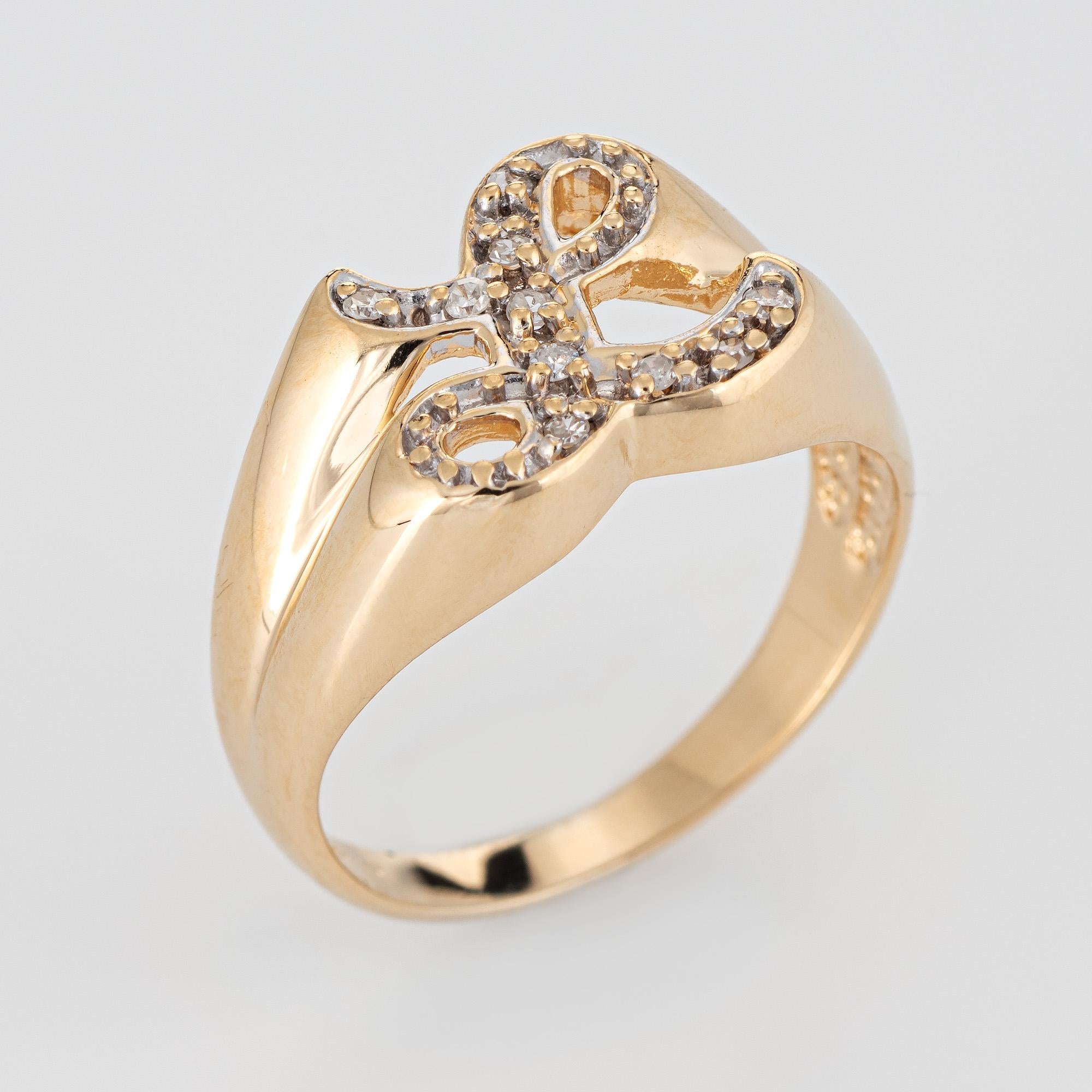 Stylish vintage letter L initial diamond signet ring (circa 1960s to 1970s) crafted in 14 karat yellow gold. 

Diamonds total an estimated 0.10 carats (estimated at I-J color and SI1-I1 clarity). 

The cursive letter 'L' is set with diamonds in an