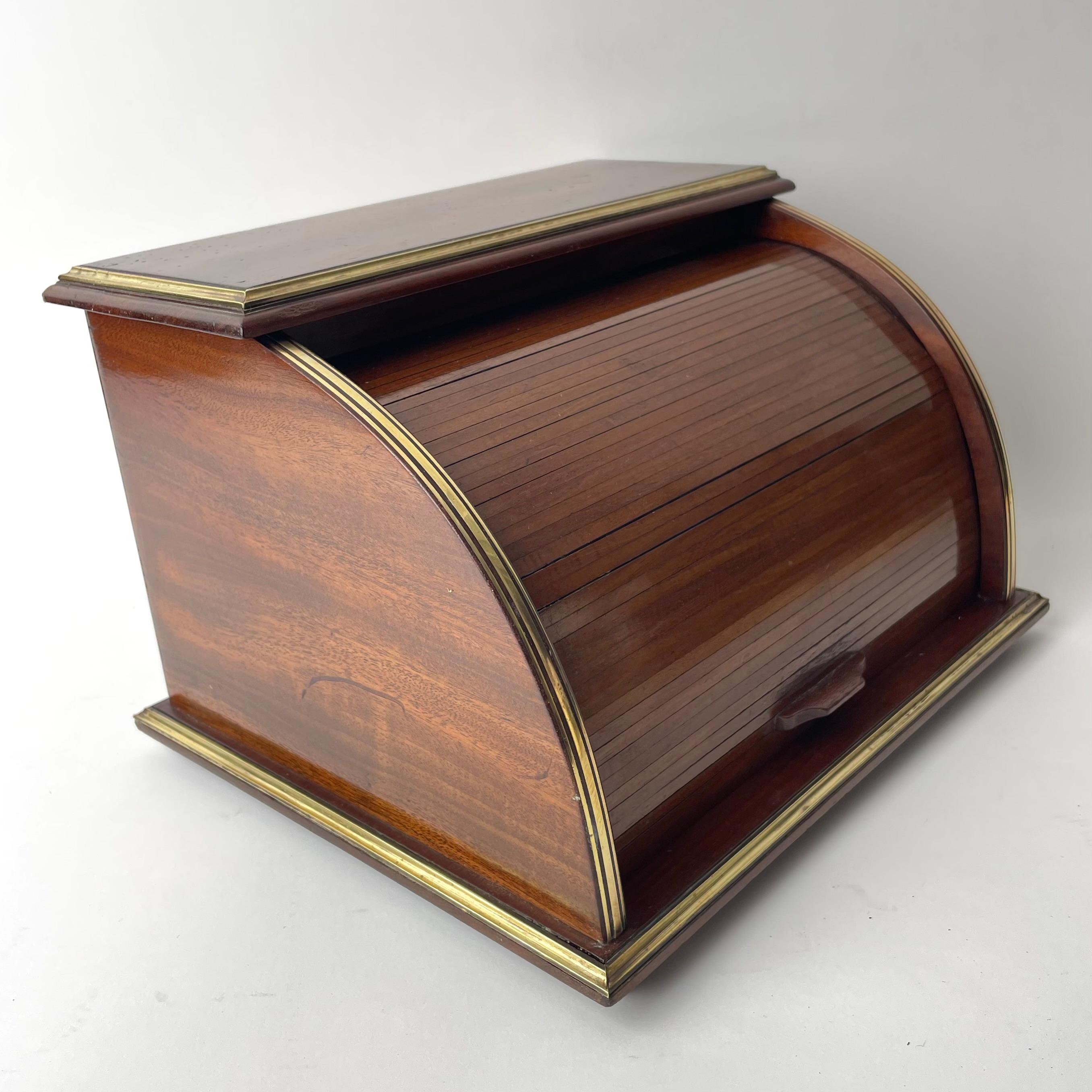 Letter Stand in Mahogany (Swietenia mahagoni) and Brass details. 

Closable by a rollable jalousie-like covering. The letter stand consists of a rounded main volume, made of mahogny (Swietenia mahagoni) and with brass details, which hold three