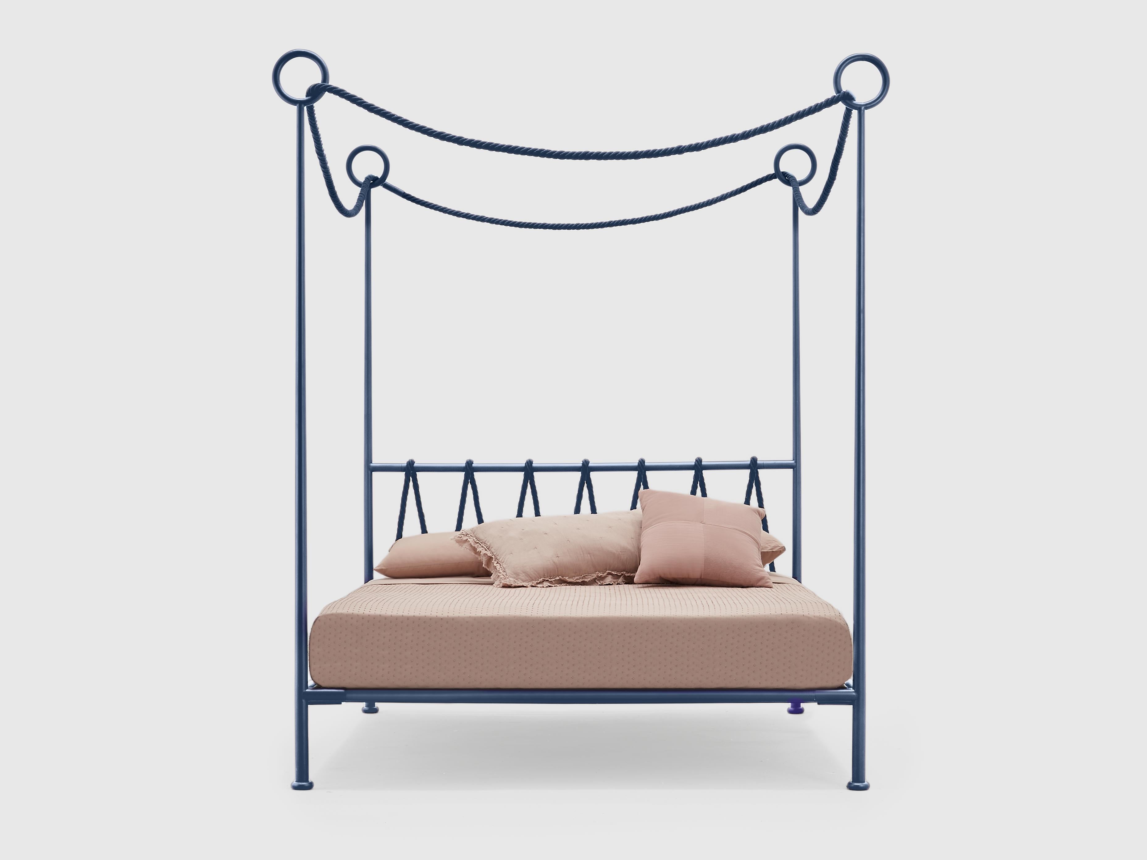 The frame design is elegant and clean. The round wrought iron
profile rises from the foot of the bed, forming the posts and drawing
solid iron circles on their summit, which welcome a soft colored cotton
top. This top elegantly rises above the bed