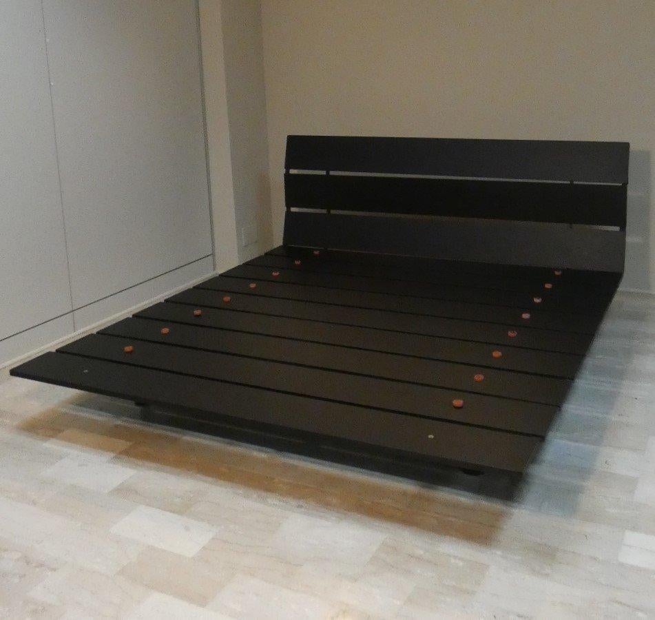 Letto matrimoniale dal nome e dall'ispirazione giapponese in cui il designer semplice prevede il piano d'appoggio del materasso e lo schienale formati da doghe in legno. Queste costituendo la 