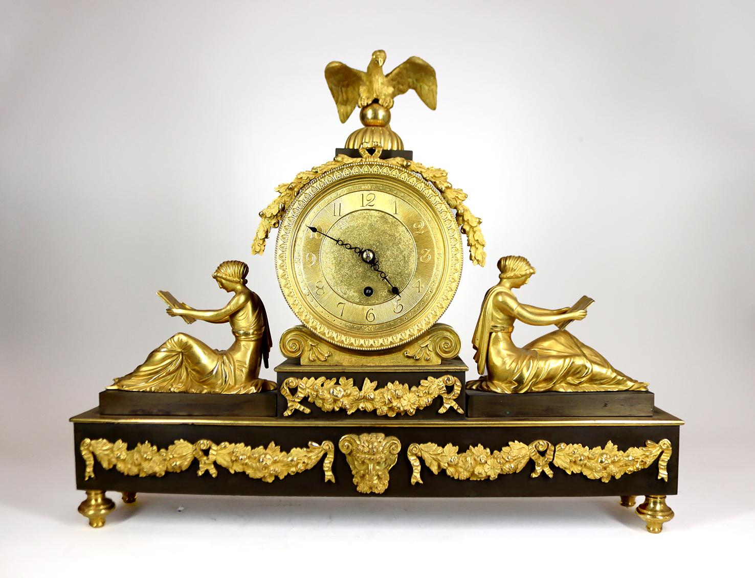This impressive mantel clock with an eight day single fusee movement evokes the concept of time well spent in learning. It is crowned by Jupiter's eagle who bears sacred oak garlands above the dial, whose Ionic capital cradle is framed by addorsed