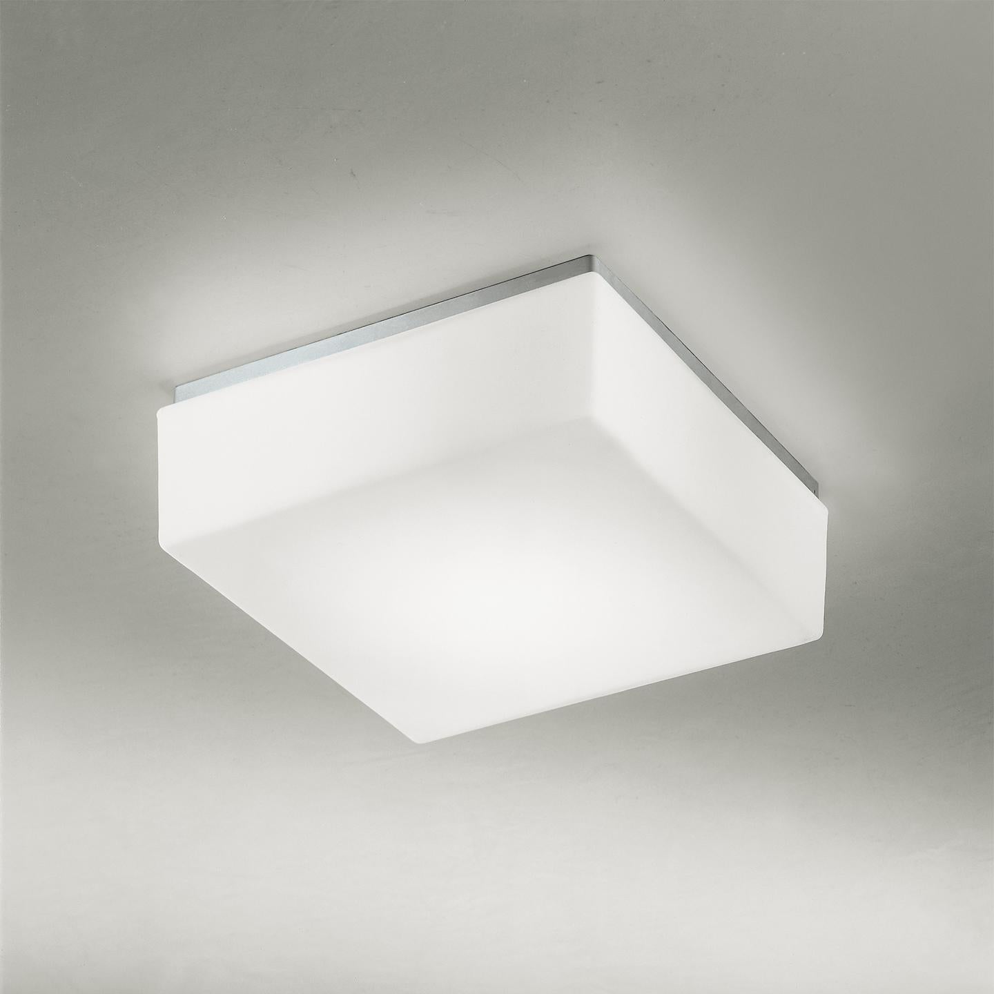 The cubi ceiling/wall lamp, designed in 2000, is an icon of Leucos. Its cubic form is surprising for handmade glass, which makes it a delightful lamp. Its hand blown satin white diffuser is made of multiple layers of glass to create a rich, white