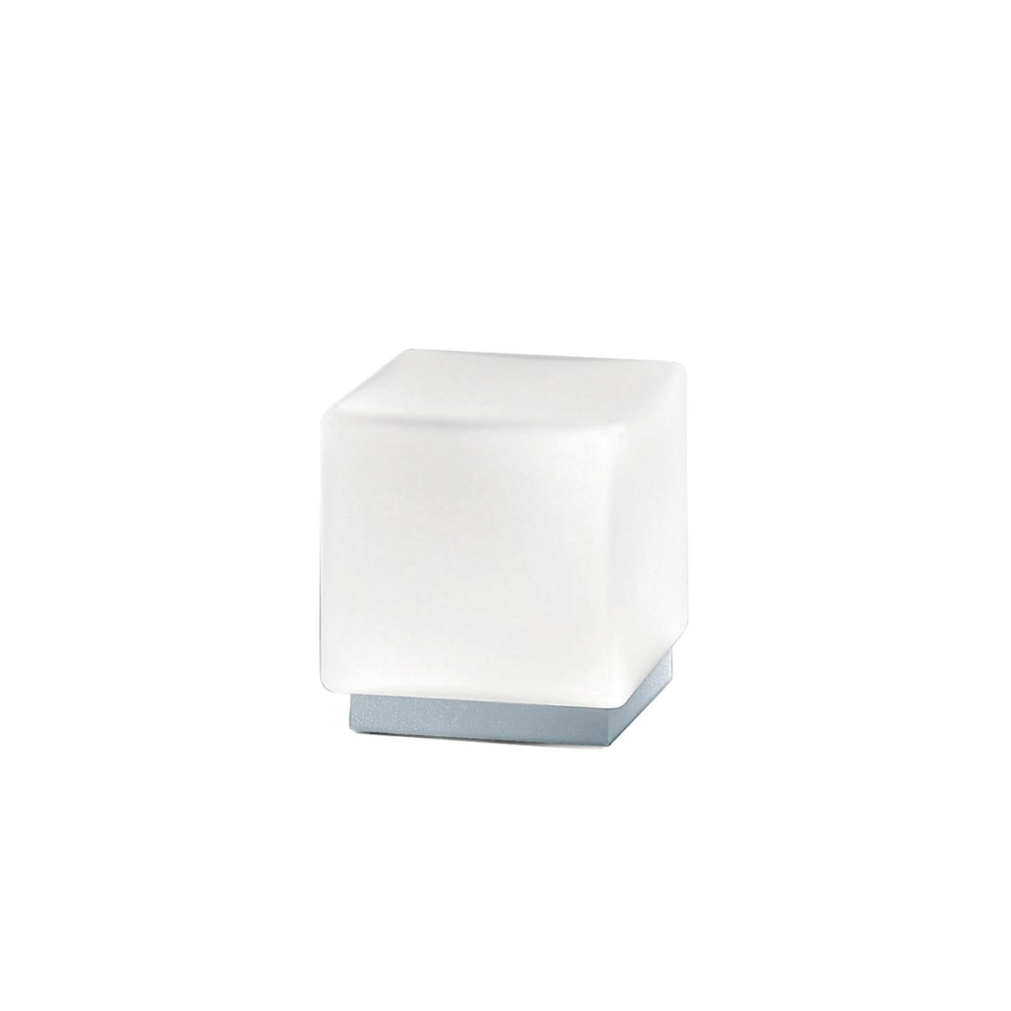 The Cubi Table Lamp, designed in 2000, is an icon of Leucos. Its cubic form is surprising for handmade glass, which makes it a delightful lamp. Its hand-blown satin white diffuser is made of multiple layers of glass to create a rich, white look.