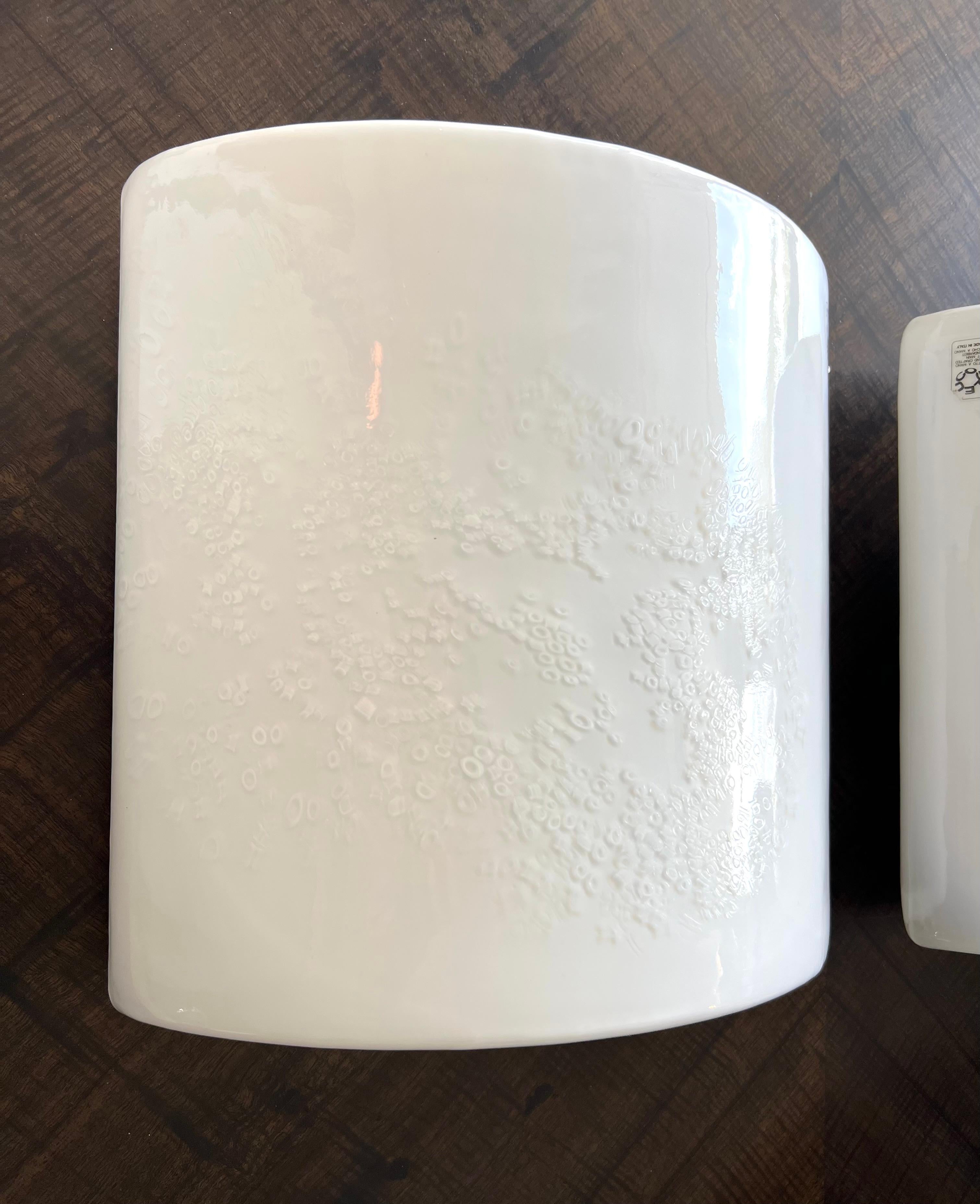 Un par de apliques de Murano de los años setenta.  Los grandes cuerpos blancos son rectangulares con frente radial de vidrio blanco translúcido con inclusiones de caña blanca aplicadas de forma aleatoria.  Estas inclusiones crean profundidad y