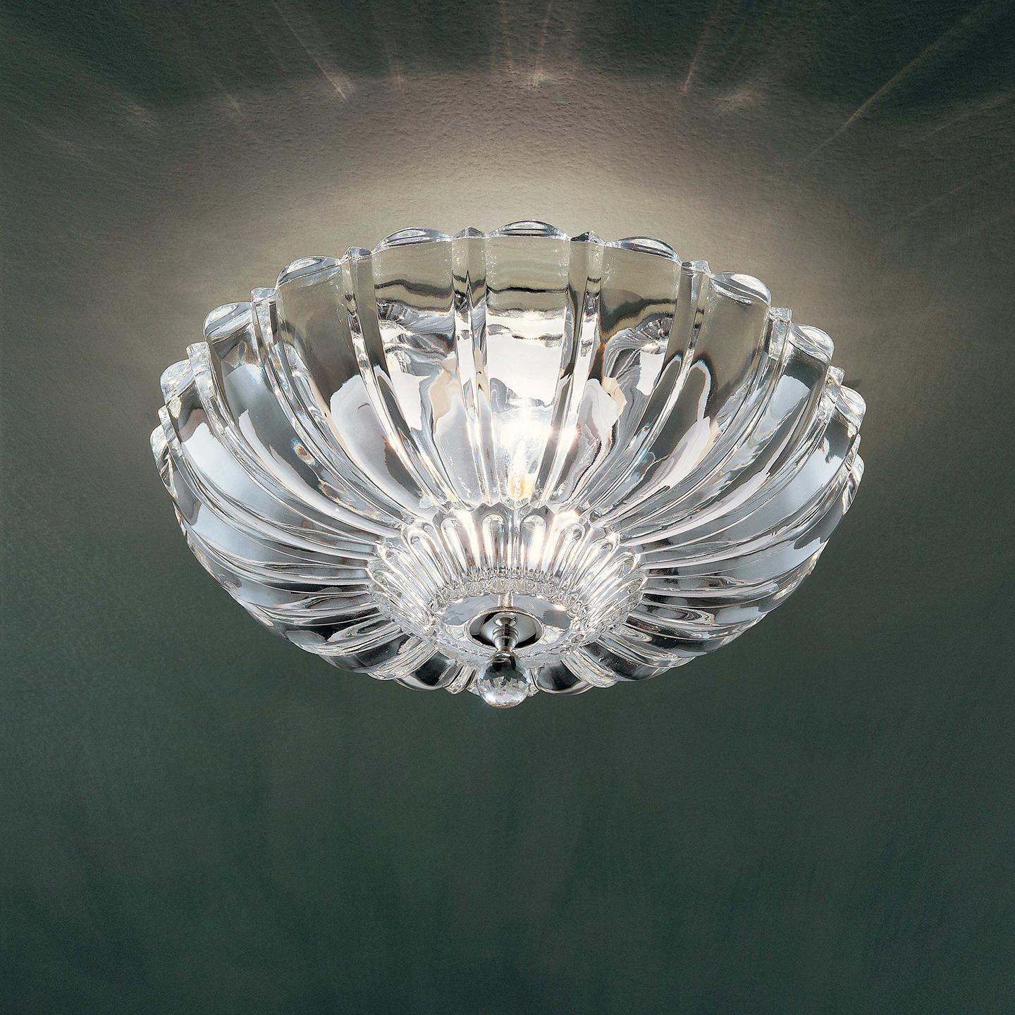 Pascale was designed by Leucos Design Lab in 2005 as a stunning transitional lamp. Pascale is a shimmering crystal lamp handmade in Italy using a pressed rib mold. The Pascale collection includes a ceiling and a wall lamp. Made of genuine crystal.