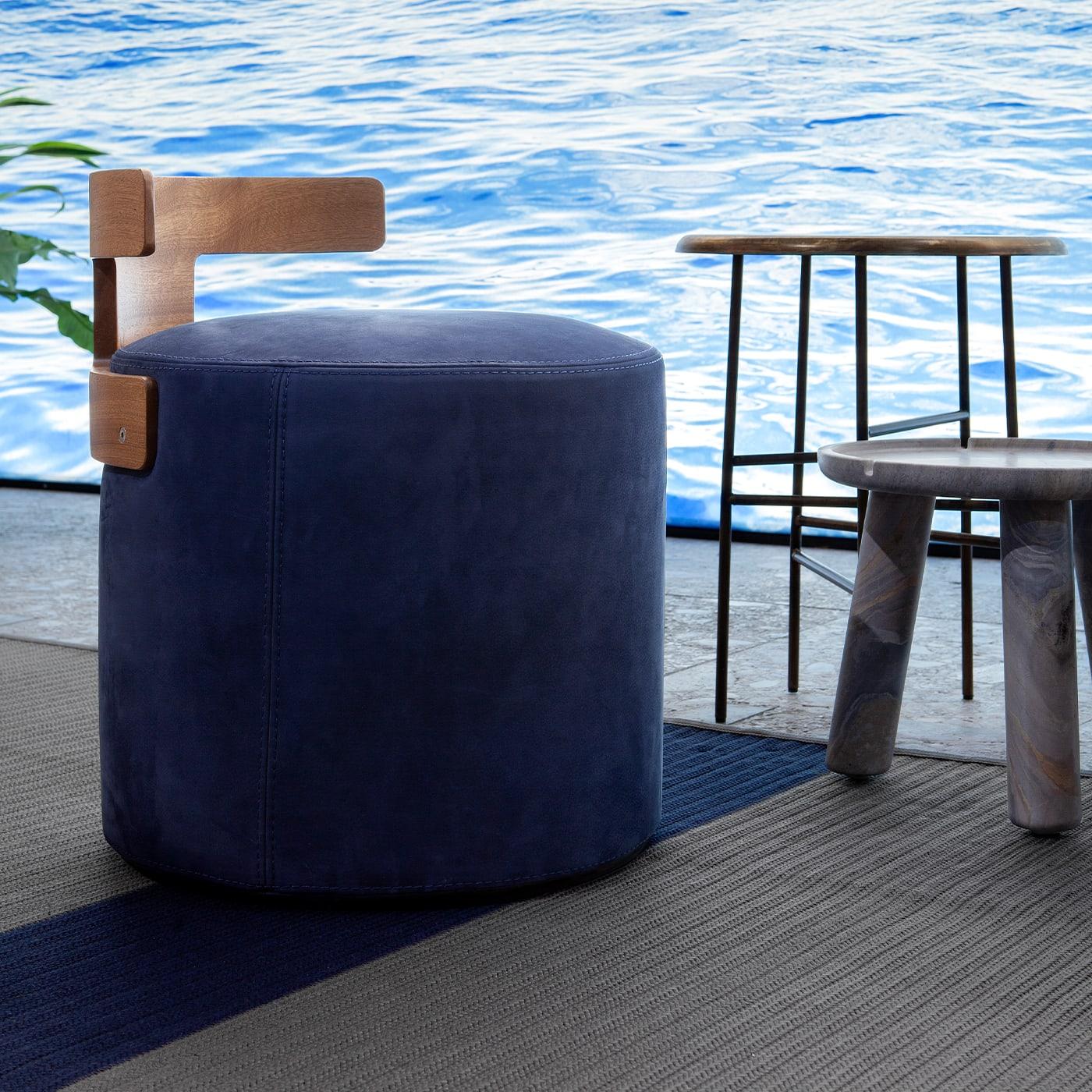 Clean and sophisticated lines define the singular yet customizable silhouette of this extremely comfortable pouf. Upholstered with blue Nabuk leather and softly padded, the cylindrical seat is enriched with a T-shaped backrest in mahogany.