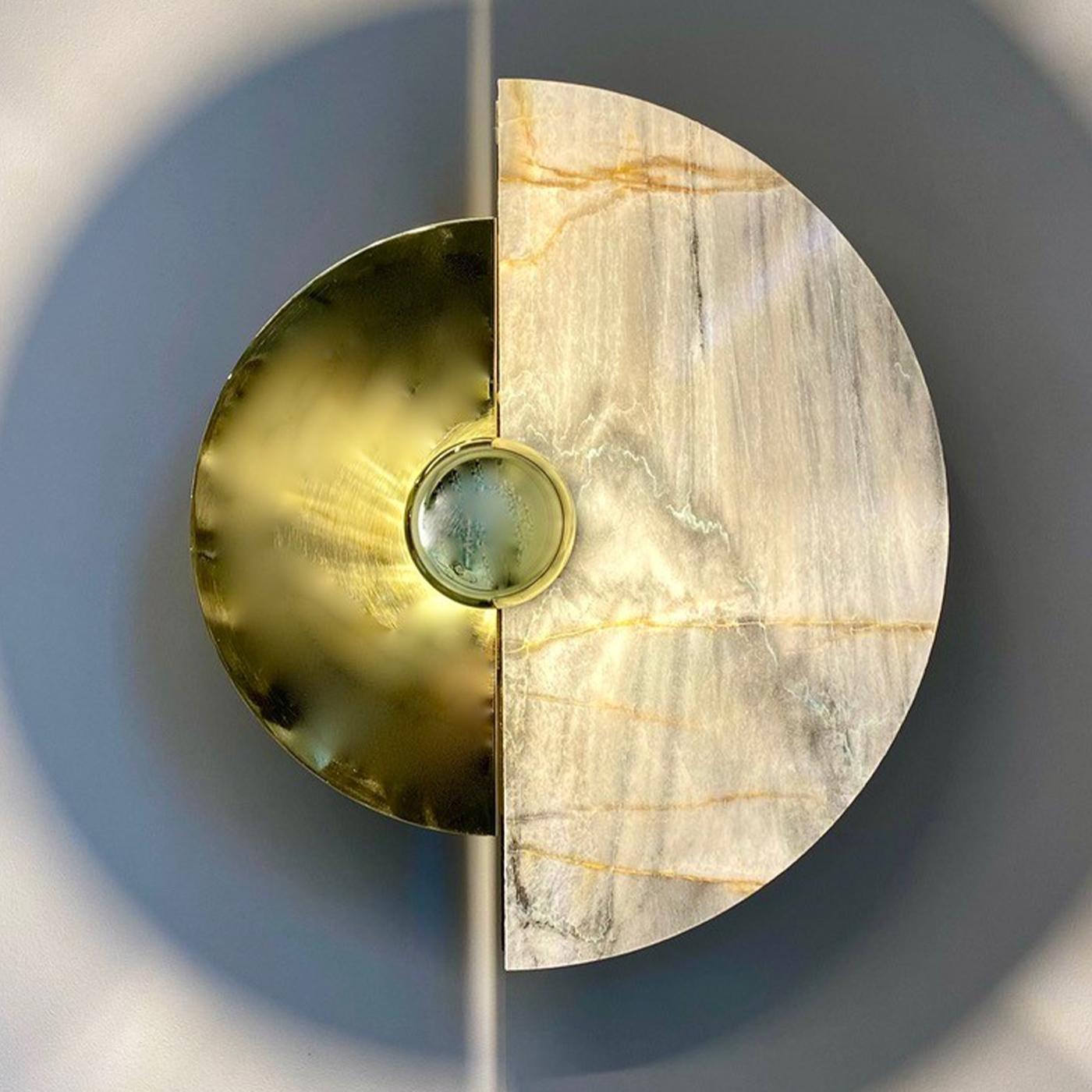 Levante Wall Sconce in polished brass and Brita blue onyx, composed of half disks that can be moved on the central body. Play with the various positions (30 degrees, each) of the disks to create magic shade and light effects on the wall. Please,