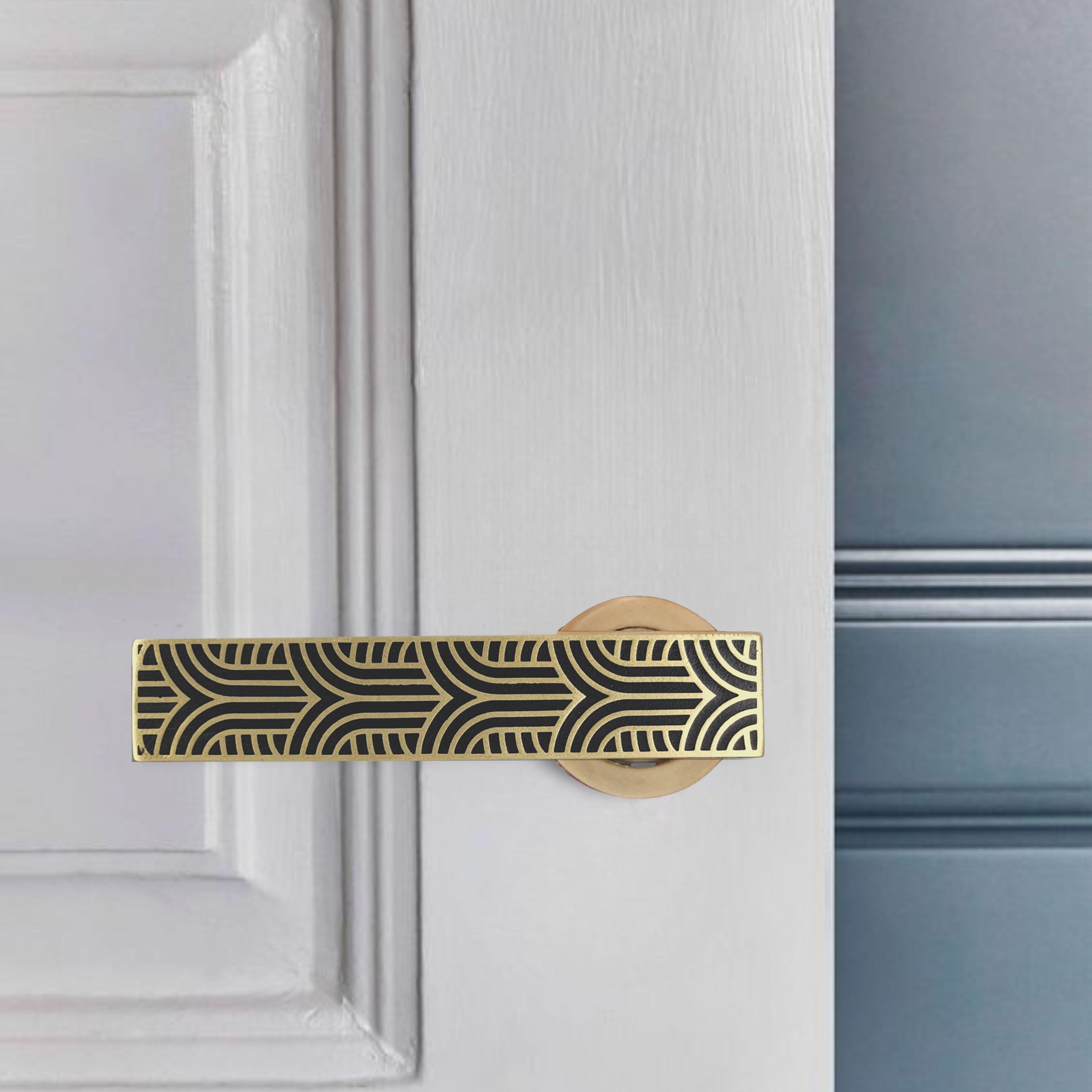 Cette béquille en laiton massif est entièrement réalisée à la main dans notre atelier et s'inspire du langage graphique du design Art déco. La surface gravée présente un motif géométrique rythmé, mis en valeur par un contraste saisissant entre la