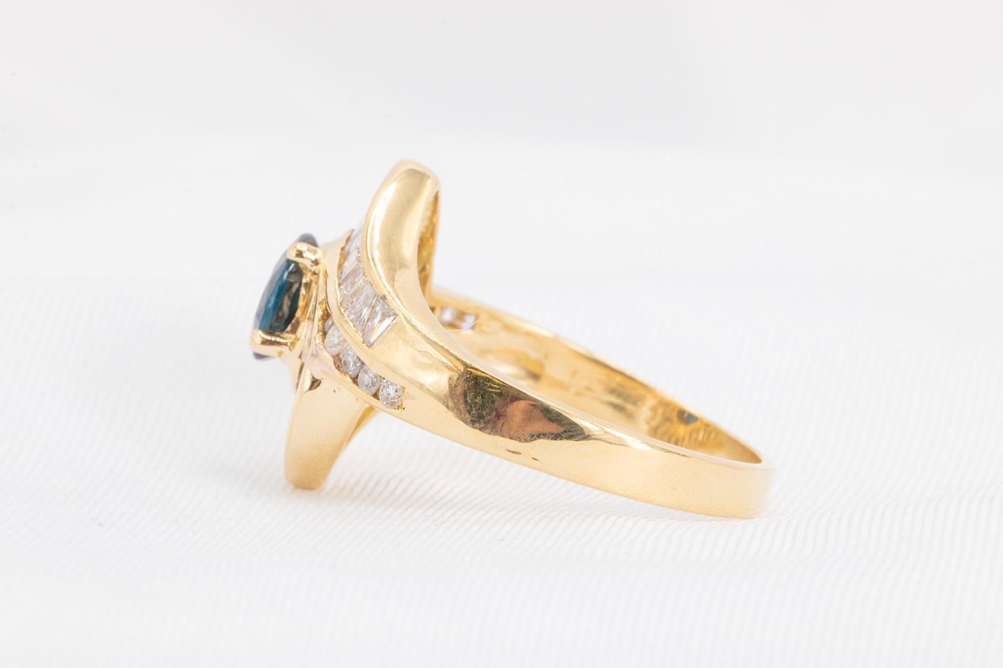 This exquisite vintage Le Vian ring from the 1980s is crafted in 14k yellow gold and showcases a captivating dark blue oval sapphire, approximately 0.90 carats. The centerpiece is beautifully complemented by a stunning combination of baguette and