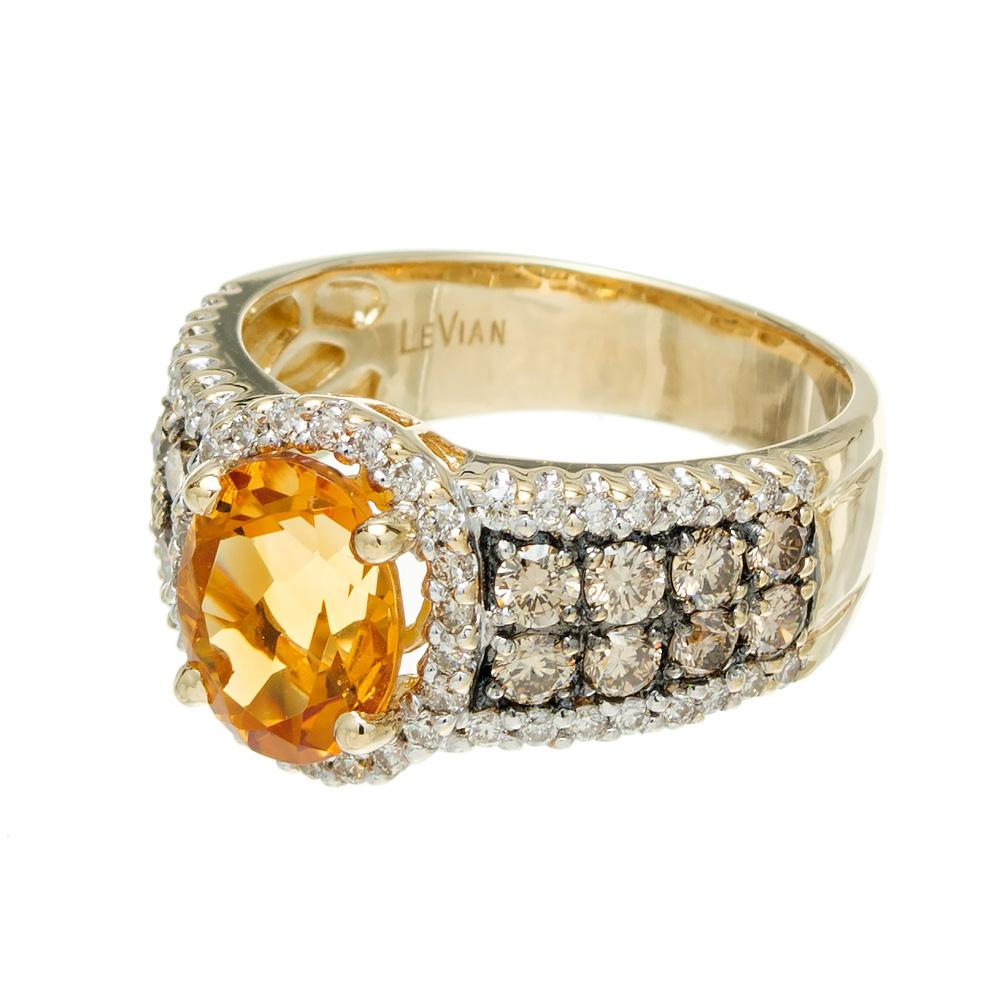 Citrine and diamond ring, from the designer Levian. Brightly colored oval center citrine set in a 14k yellow gold setting with champagne/chocolate and white accent diamonds. 

1 oval orange citrine, approx. 1.70cts
16 round brown chocolate diamonds,