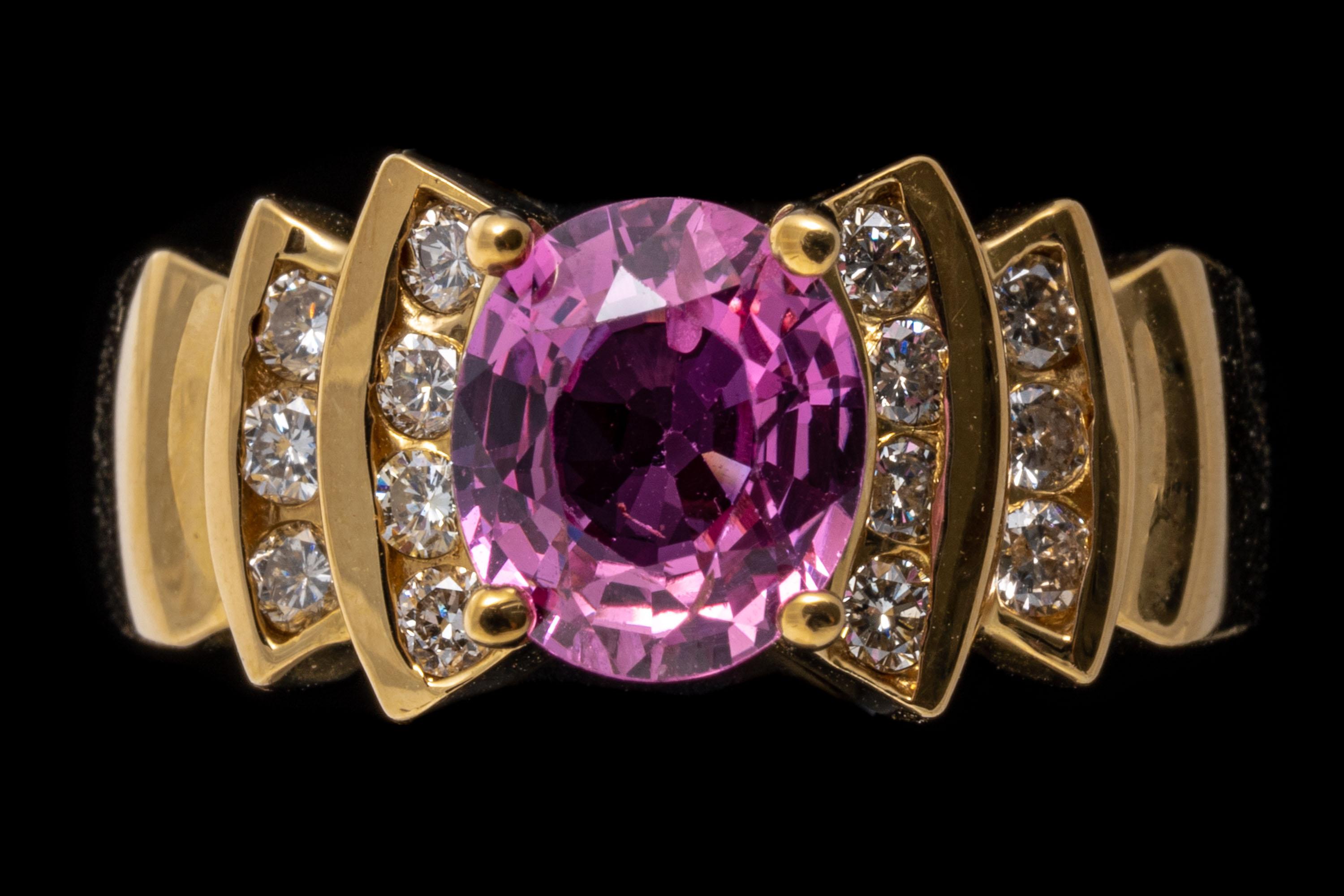 18k yellow gold ring. This beautiful, colorful ring features a faceted oval shape, deep pink color pink sapphire center stone, approximately 1.43 CTS and prong set. Flanking the stone are curved, stepped sides, set with round brilliant cut diamonds,