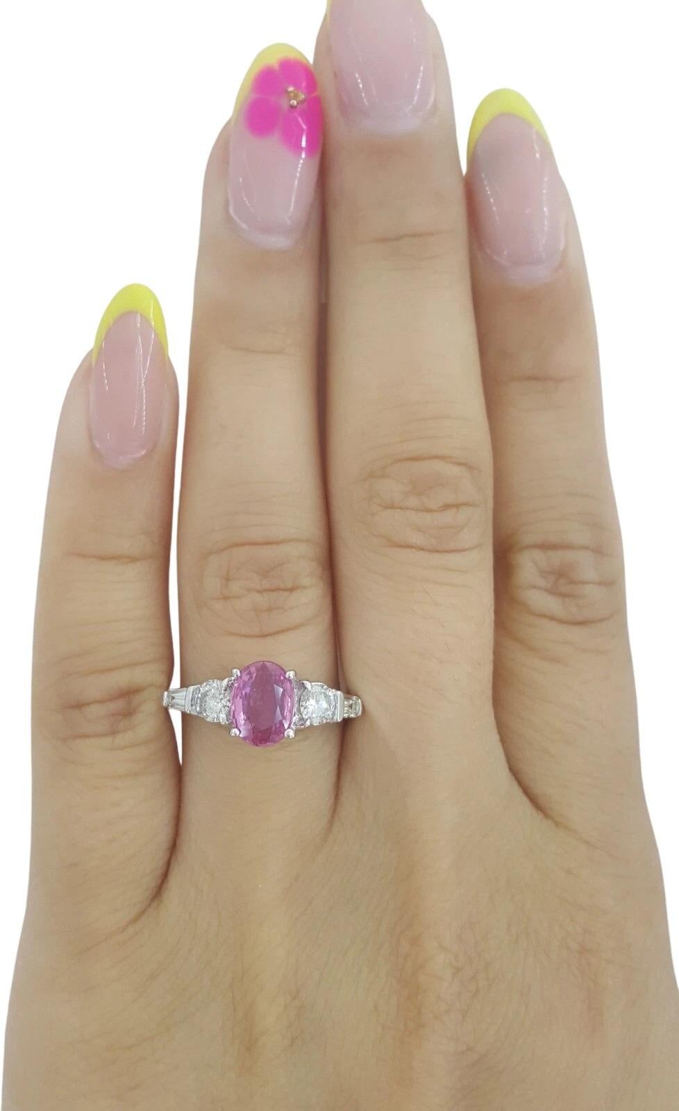 Célébrez l'amour avec cette vibrante bague LeVian à trois pierres, ornée en son centre d'un saphir rose ovale naturel de 1,50 carat. Le saphir présente une couleur riche et saturée et a probablement subi un traitement thermique, une amélioration