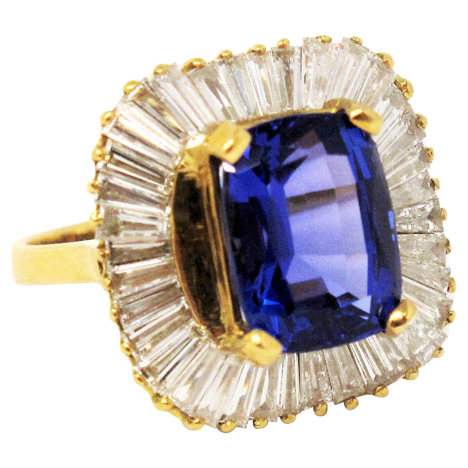 Old Hollywood glamour meets modern day elegance in this absolute showstopper of a ring. The sizeable cushion cut violet tanzanite stone at the center radiates among the unique bright white baguette diamond halo. The bold sophistication of this Le