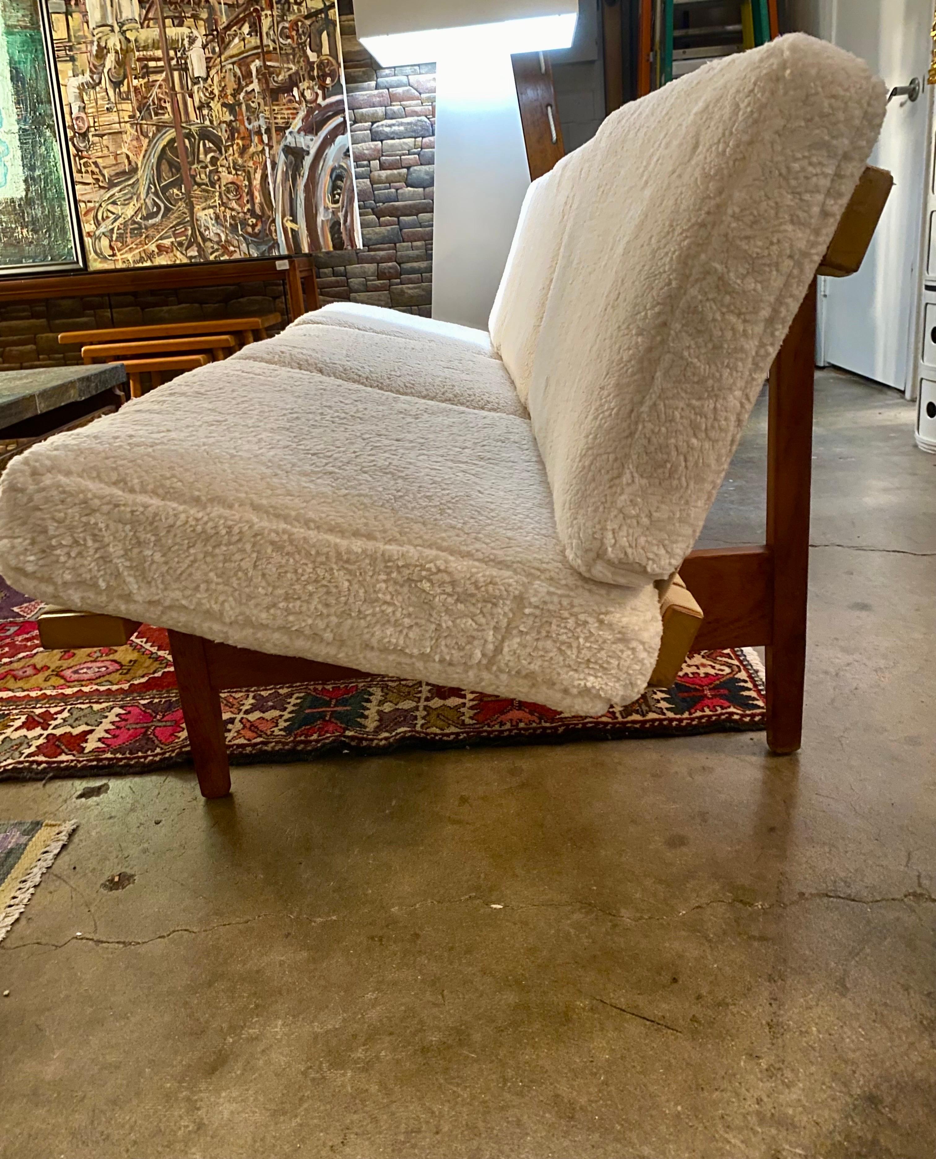Mid-century modern Lewis Butler Sofa for Knoll made with maple and walnut base, canvas straps and newly reupholstered faux shearling, circa 1950s. Dimensions: 81
