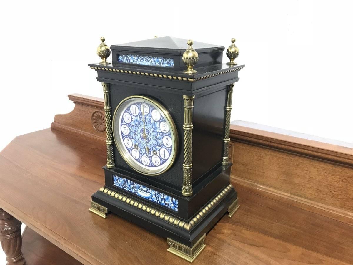 Lewis. F. Day, attributed, an Aesthetic movement ebonised and enamel mantle or bracket clock.
Possibly retailed by Howell & James of Regent St.
A French striking 8 day movement with a blue and white stylised ceramic dial with incised