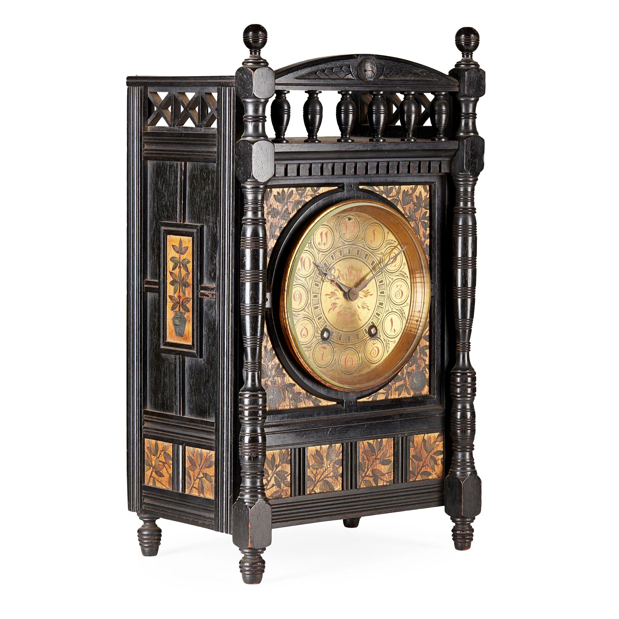 Lewis Foreman Day, for Howell, James and Sons.
An Aesthetic Movement ebonized and polychrome painted mantle clock with a carved floret to the centre of the arched and turned gallery flanked by turned finials, with a dentil moulding below, and criss