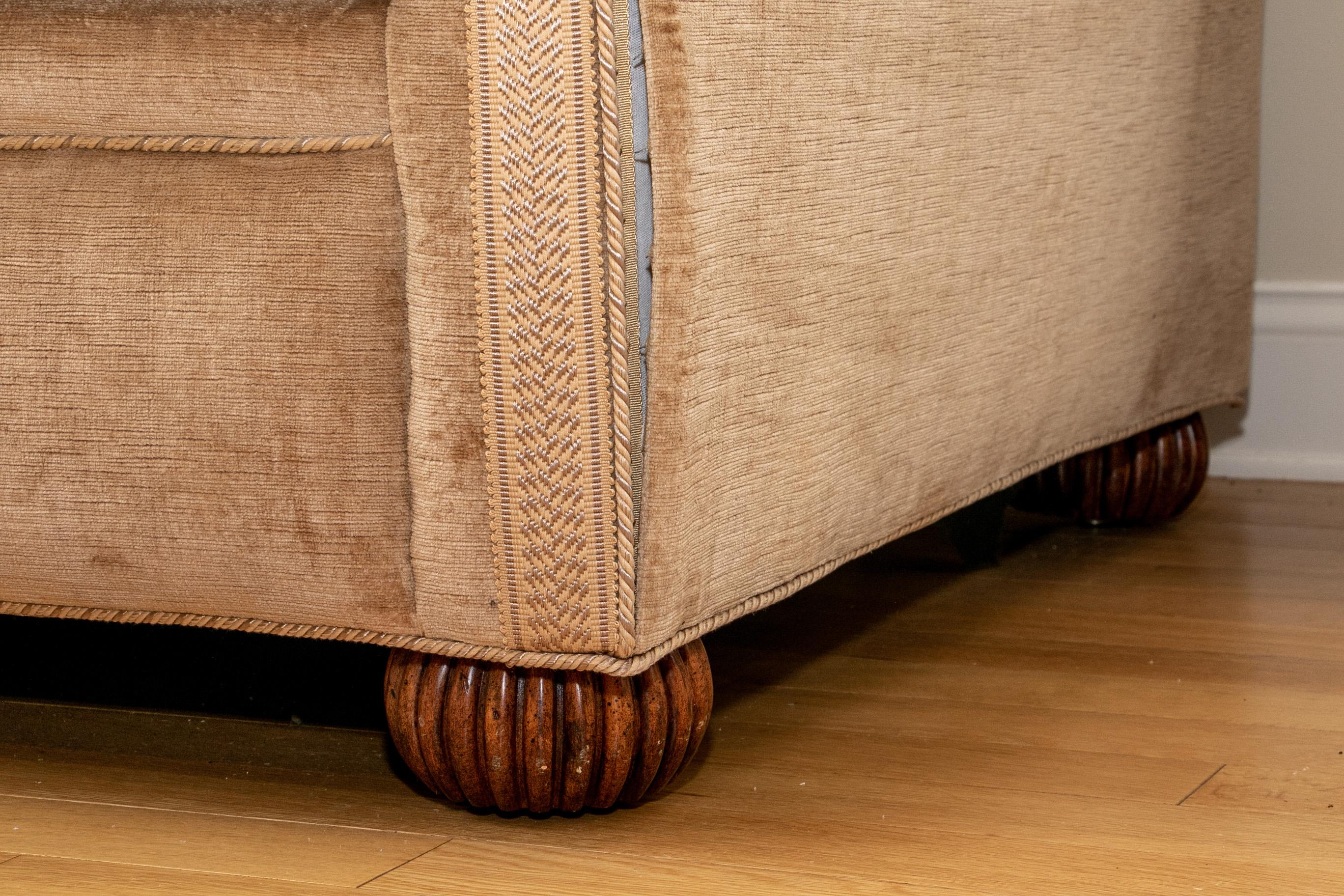 Classic Knole House style sofa with adjustable sides, an angled back and sides, carved artichoke form finials on the back corners. Raised on carved fluted bun feet. The sofa has a very well tailored custom upholstery in a textured deep Camel velvet