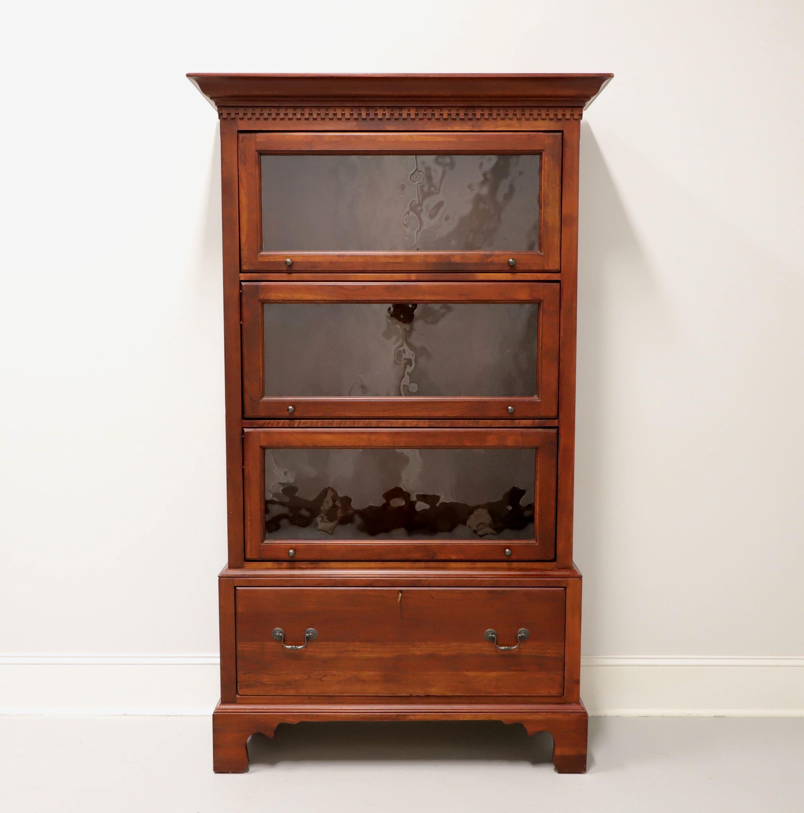 A Chippendale style barrister bookcase from quality furniture maker Lexington, from their Bob Timberlake Collection. Solid cherry with brass hardware, crown & dentil molding to top, encased glass doors, and bracket feet. Features three flip up slide