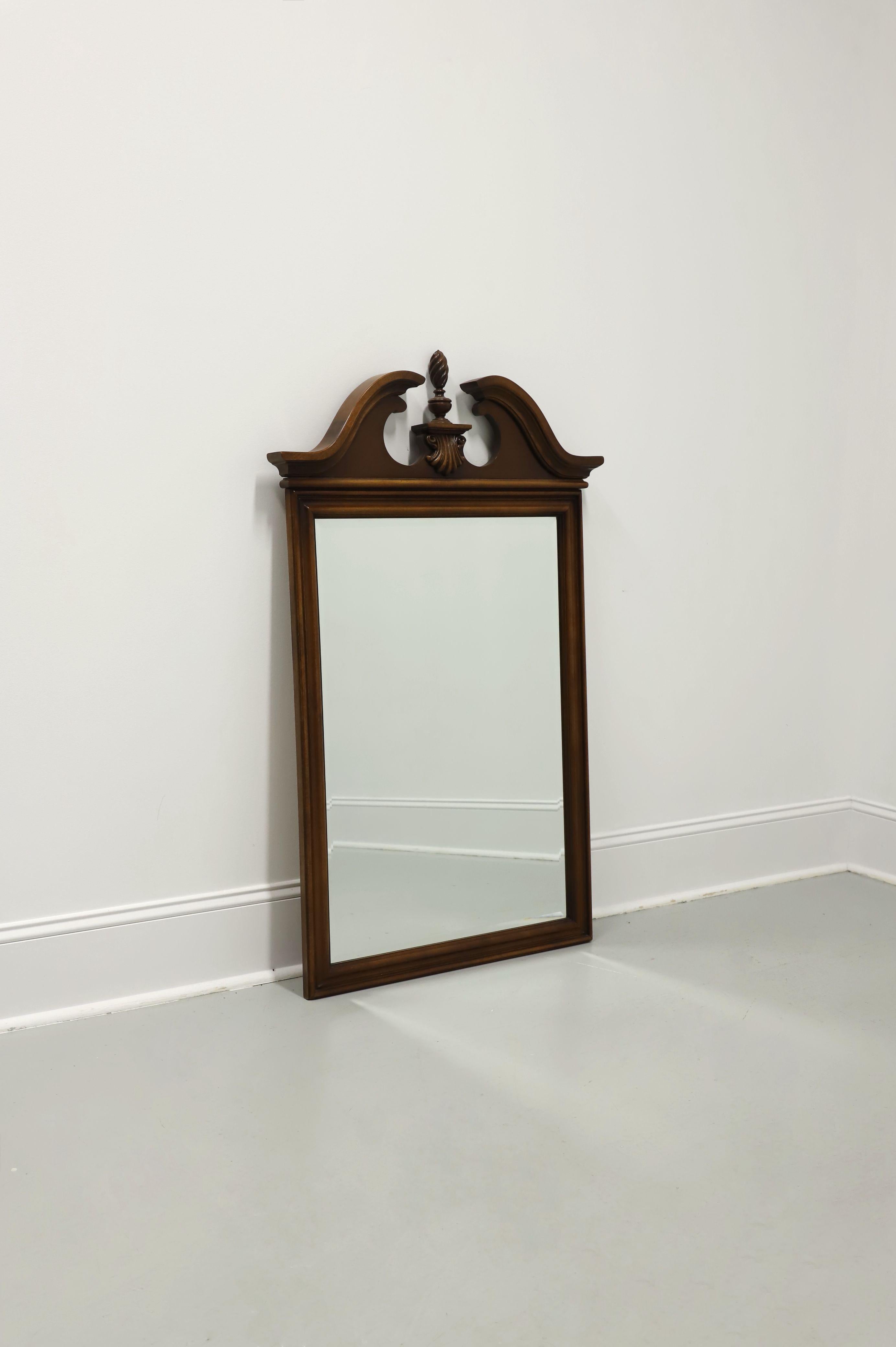 A Traditional Chippendale style wall mirror by Lexington Furniture. Beveled mirrored glass in a cherry wood frame with a pediment & center finial to the top, and a flat bottom. Made in the USA, in the late 20th Century.

Style #: 490-204

Measures: