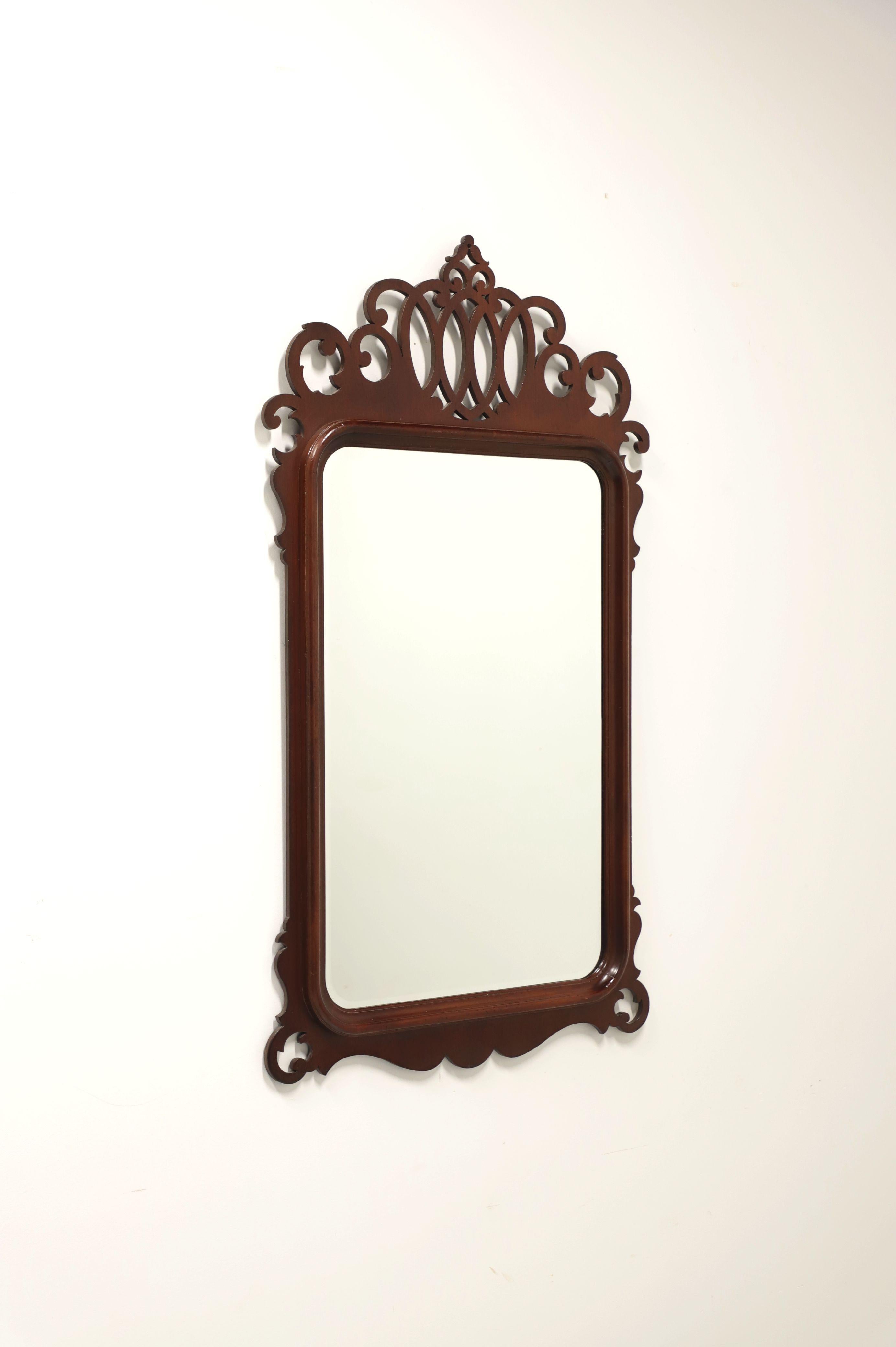 A large Chippendale style wall mirror by Lexington Furniture. Bevel edge mirrored glass, mahogany frame with decoratively carved fretwork pediment to top and decorative carving to bottom. Made in the USA, in the early 21st Century.

Style #: