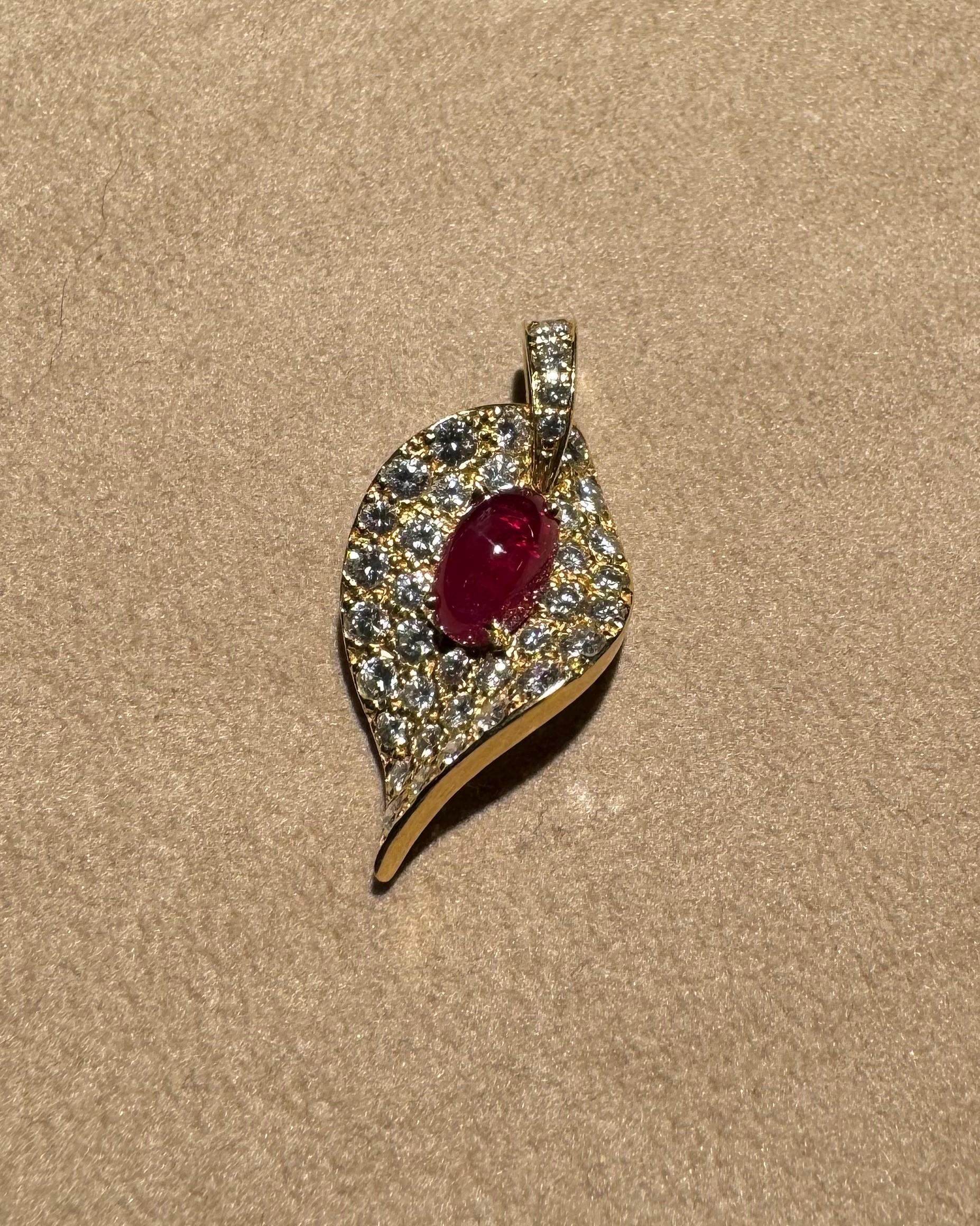 Ciondolo in oro rosa 18 carati (4,95 g), caratterizzato da:

- 1 cabochon ovale di rubino (9,4x6 mm)
- 38 diamanti taglio brillante (1,8-1,9 mm, TW/VSI)

Un design elegante e senza tempo realizzato alla perfezione. 