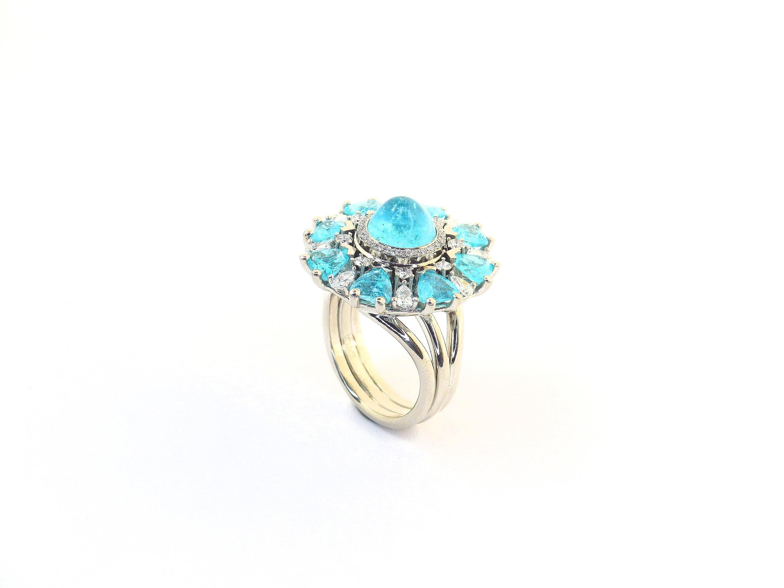 This 950/ Platinum (31.27gr) Ring is set with 8x fine Paraiba Tourmalines (facetted, trillant cut, 5x5mm, 3.34cts) + 1x Cabouchon (round, 8.5mm, 3.36cts) + 42x Diamonds (various shapes, 0.88cts, D/VS).

The top of the ring is spinning