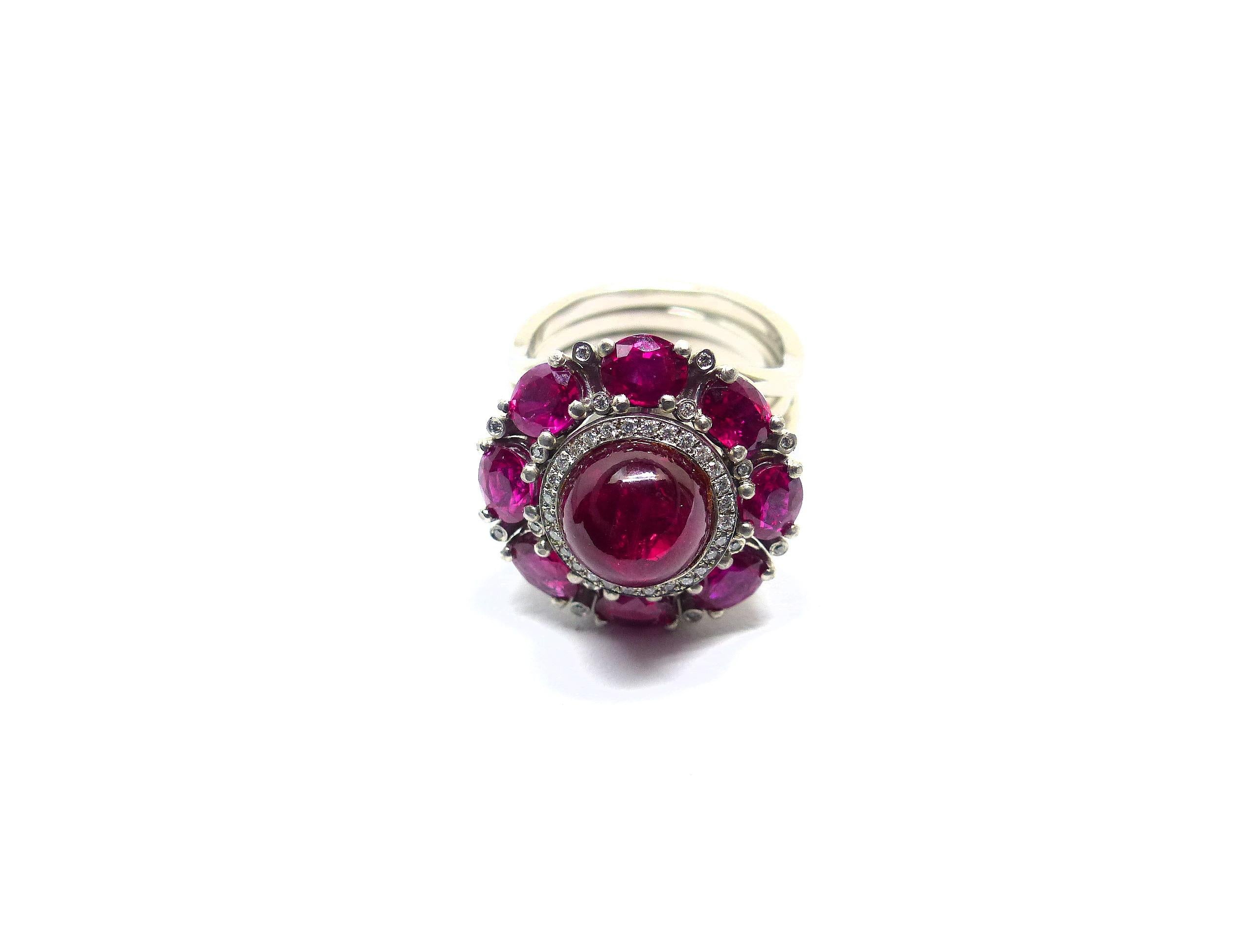 Thomas Leyser is renowned for his contemporary jewellery designs utilizing fine gemstones.

This 950/ Platinum (22gr.) Ring with 1 Ruby Cabouchon in excellent quality, 9,5mm round, 6,00cts. + 8 Rubies in excellent quality, oval 5x4mm, 3,51cts. + 44