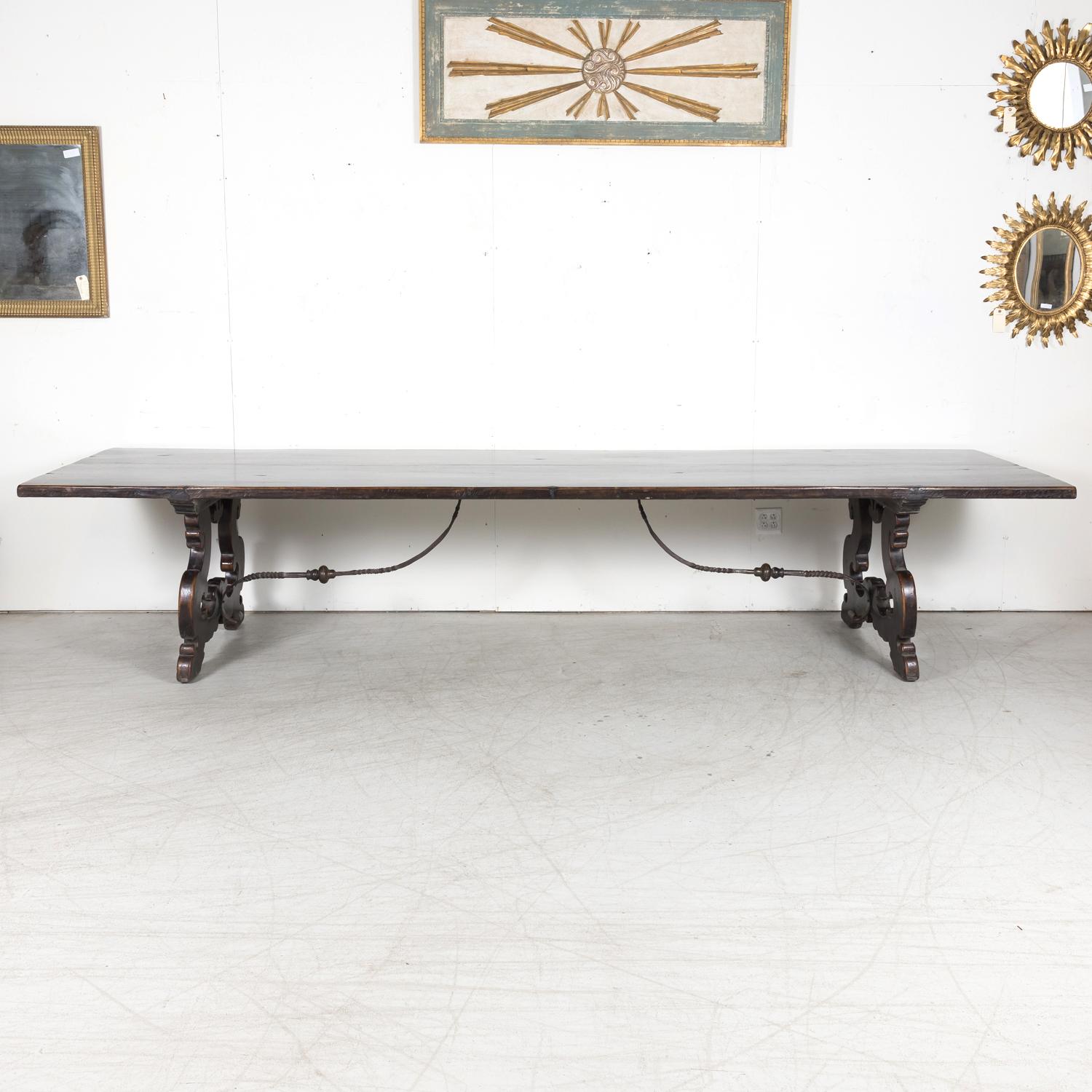 An impressive late 19th century Spanish Baroque style trestle dining table handcrafted of solid walnut near Barcelona, circa 1890s. Having a thick two-board top with a wonderful rich color and deep lustrous patination, this antique Spanish dining